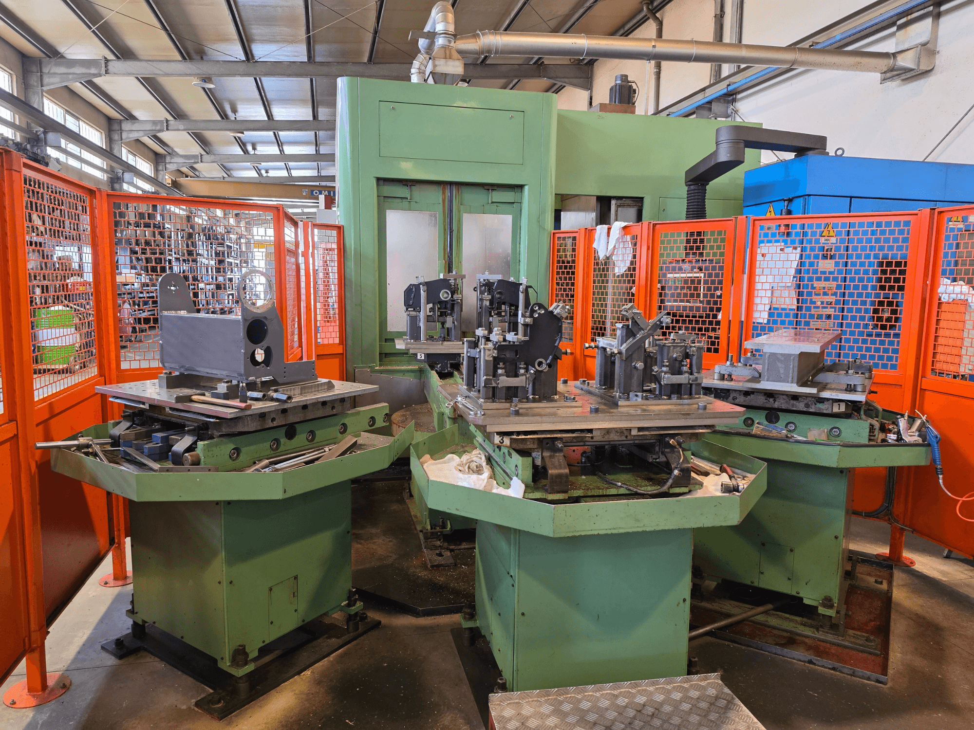 Vista frontale del centro di lavorazione orizzontale Mandelli R.S. M7U con tre stazioni di lavoro, componenti metallici e protezioni di sicurezza.