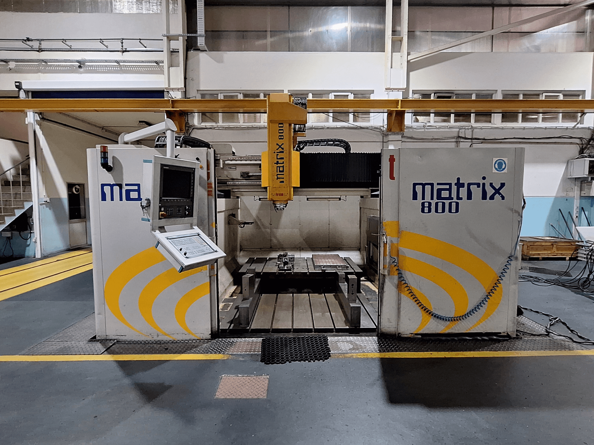 Fresatrice a portale Breton Matrix WM 800 K25 in un'officina, con pannello di controllo e piano di lavoro in vista frontale.