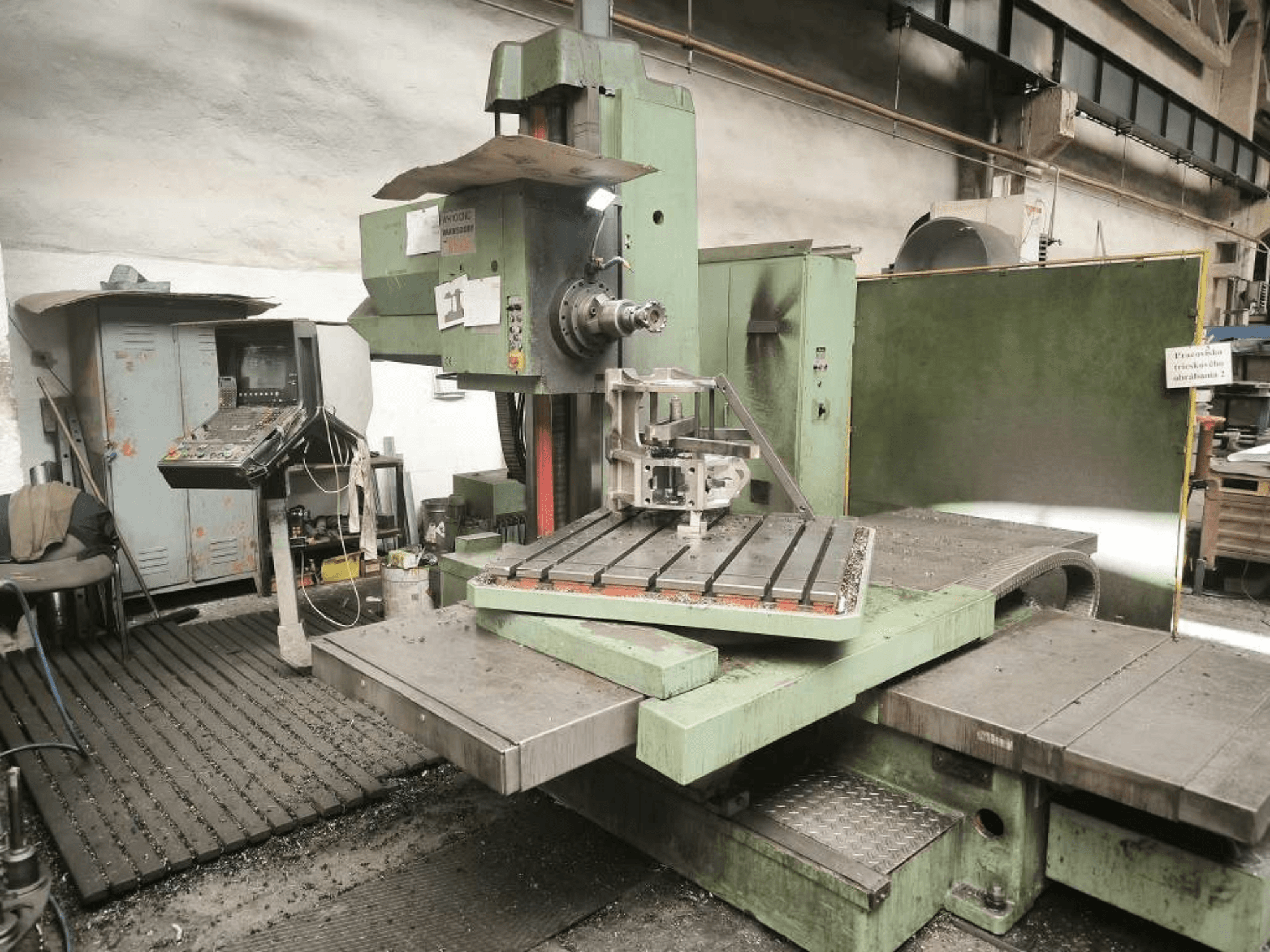 Alesatrice CNC TOS WH 10 vista frontalmente, con un pezzo lavorato sul piano di lavoro e il pannello di controllo.