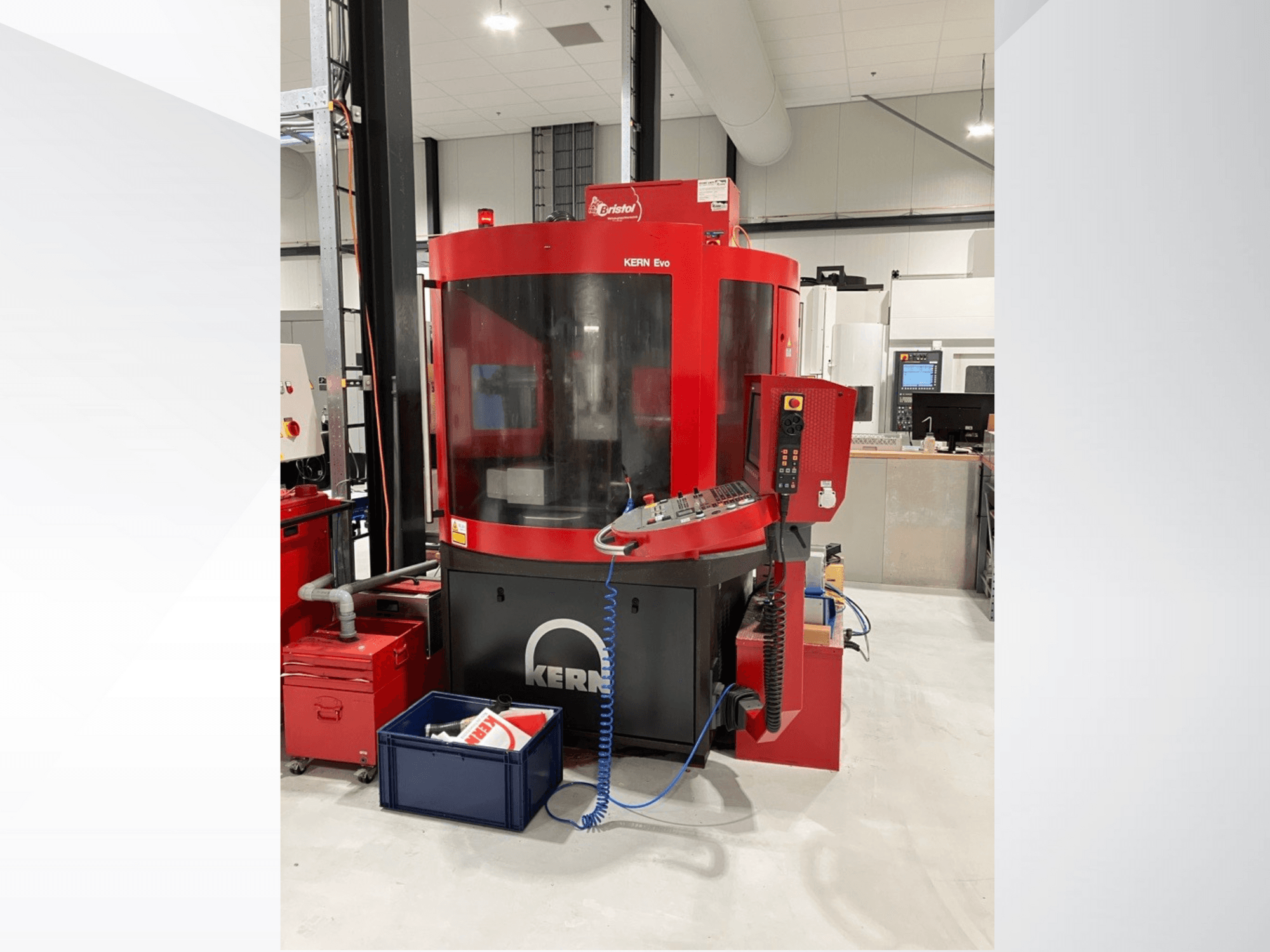 Centro di lavoro KERN Evo in rosso e nero, vista frontale, che mostra il pannello di controllo e le attrezzature circostanti in un'officina moderna.