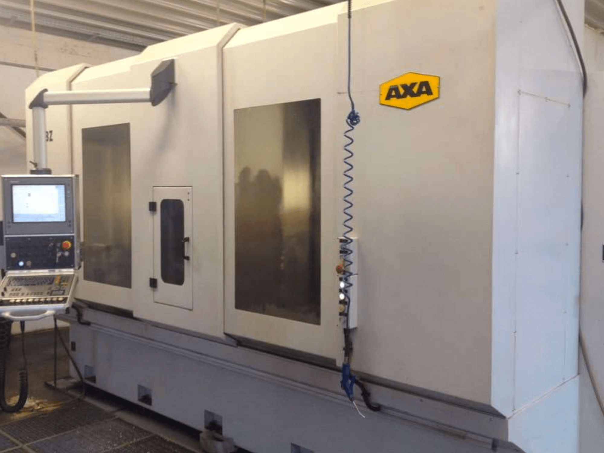 Centro di lavoro verticale AXA DBZ visto frontalmente, con pannello di controllo e ampie finestre di sicurezza trasparenti.