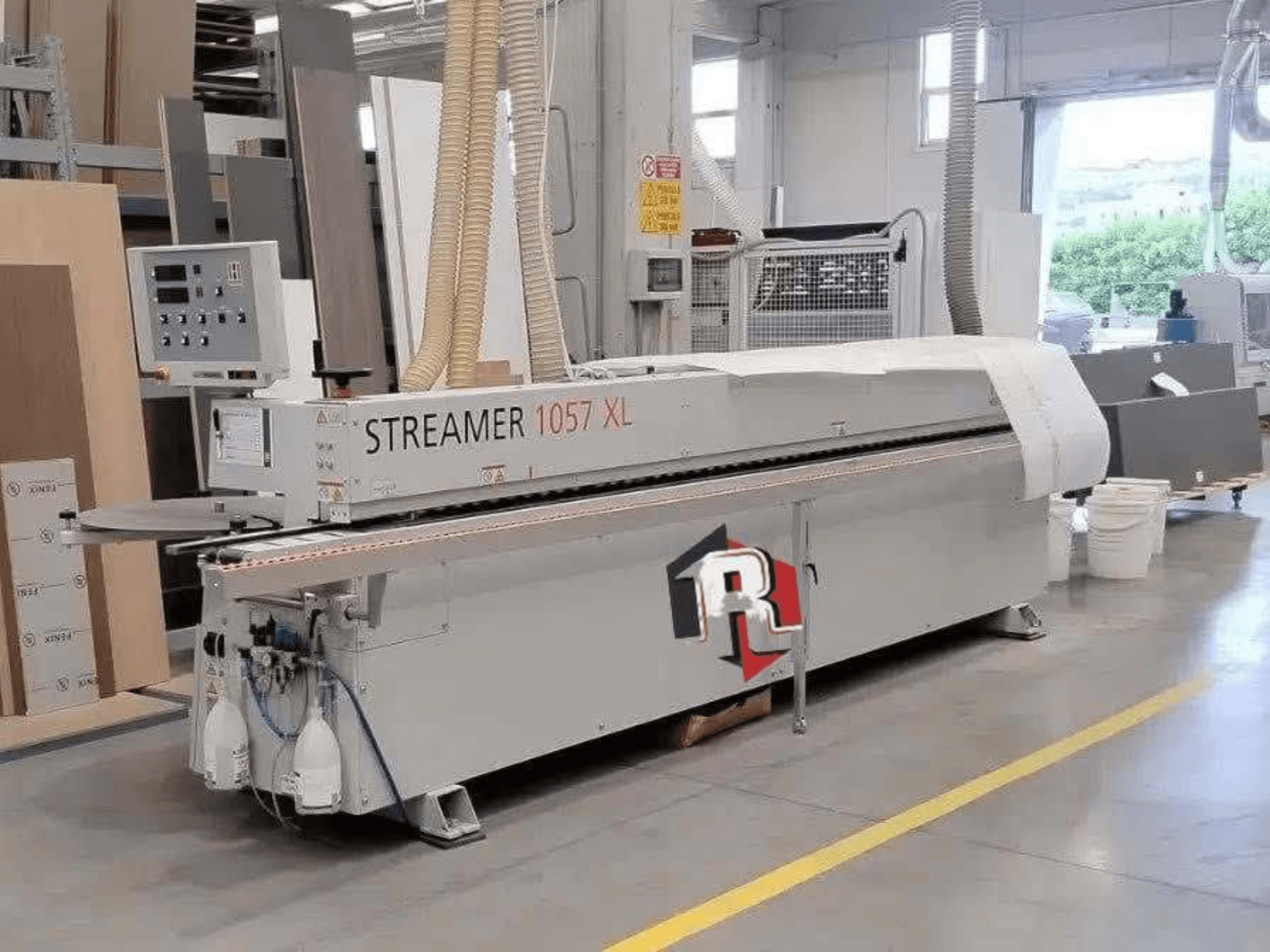 Bordatrice HOLZHER STREAMER 1057 XL in un'officina, vista laterale con pannello di controllo e tubi dell'aria visibili.