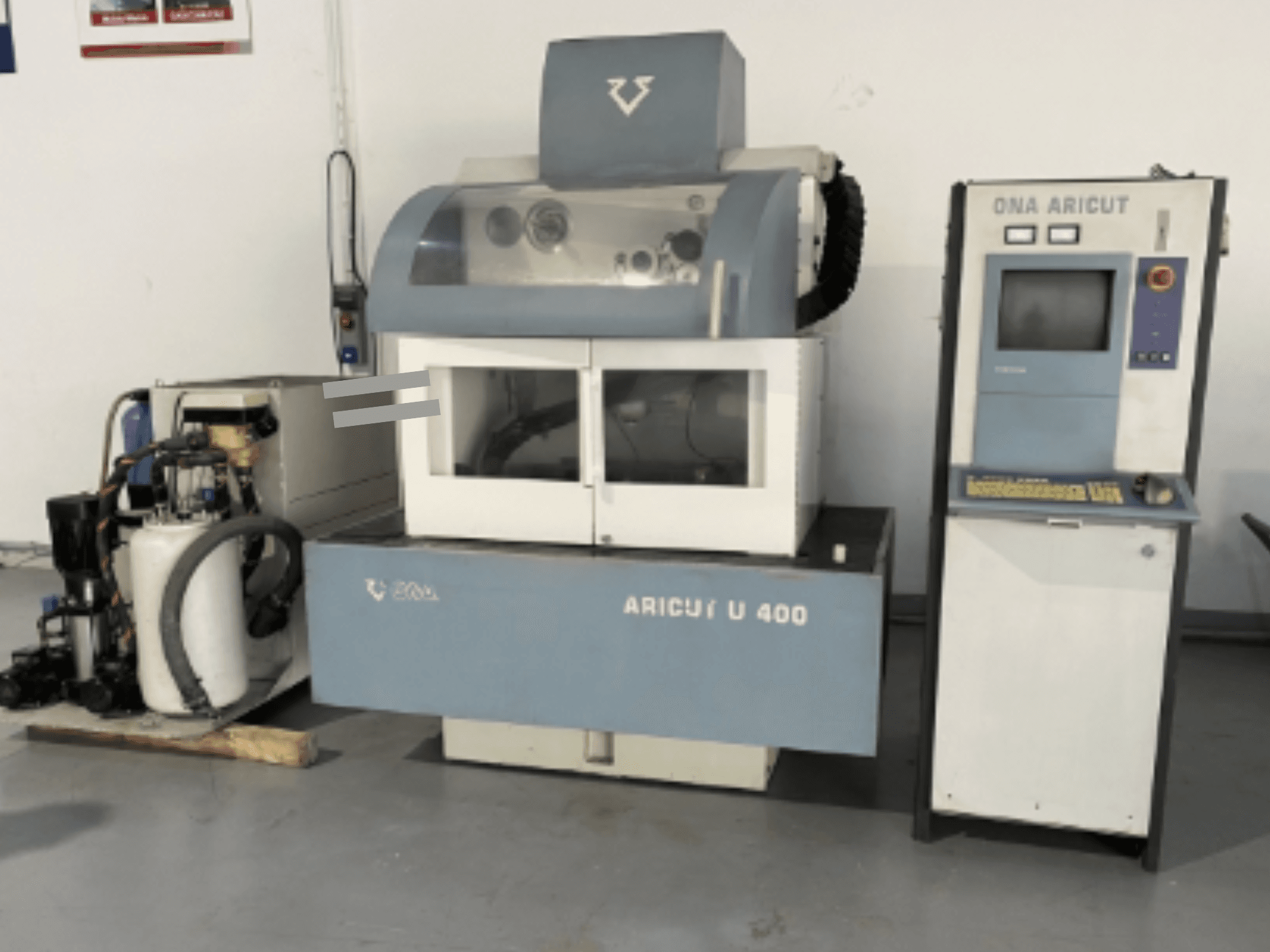 Macchina per elettroerosione a filo ONA U 400 vista frontalmente, con console di controllo e unità refrigerante sul lato.