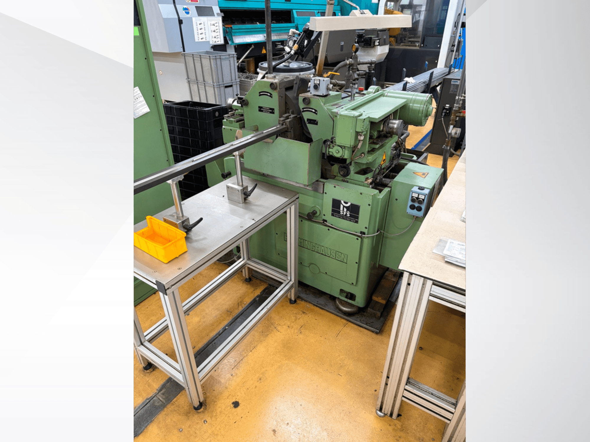 Rettificatrice senza centri HERMINGHAUSEN SR 2 W di colore verde, vista frontale, posizionata accanto a un banco da lavoro in metallo con attrezzi.