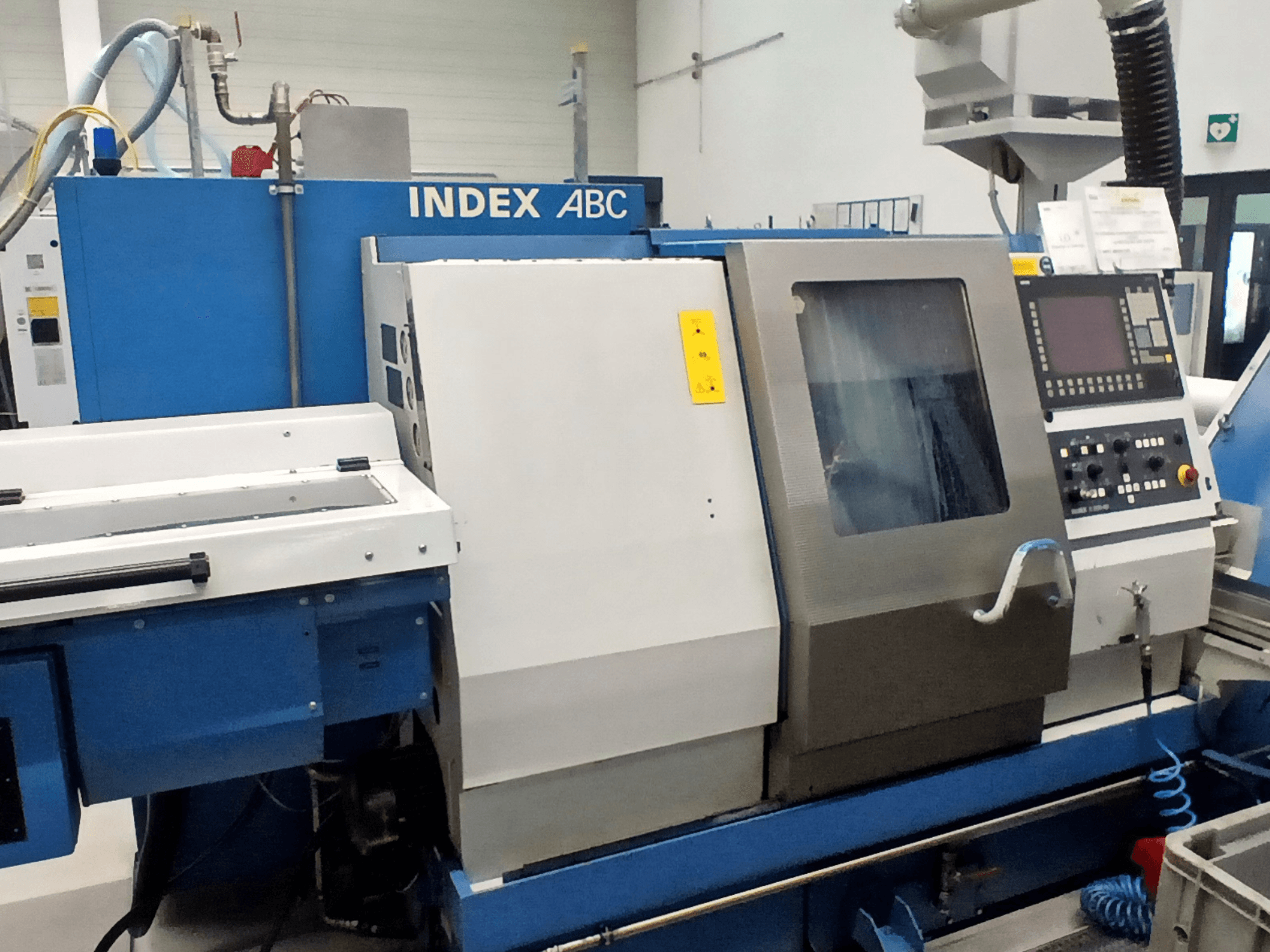 Tornio orizzontale Index ABC in blu e argento, vista frontale con pannello di controllo e area di lavoro.