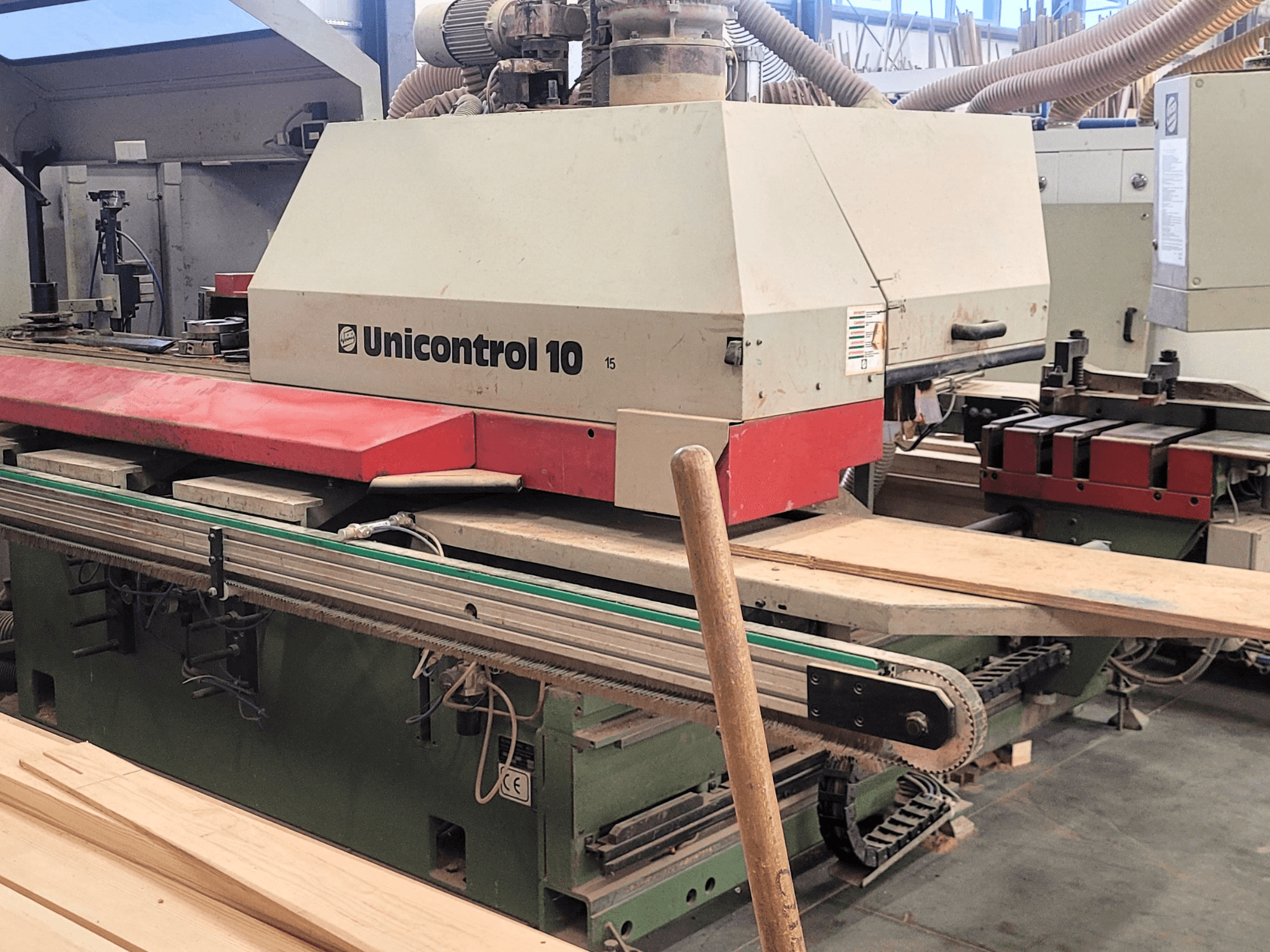 Centro di lavorazione CNC Unicontrol 10 di WEINIG/DIMTER, vista frontale con tavole di legno e attrezzature in un ambiente di officina.