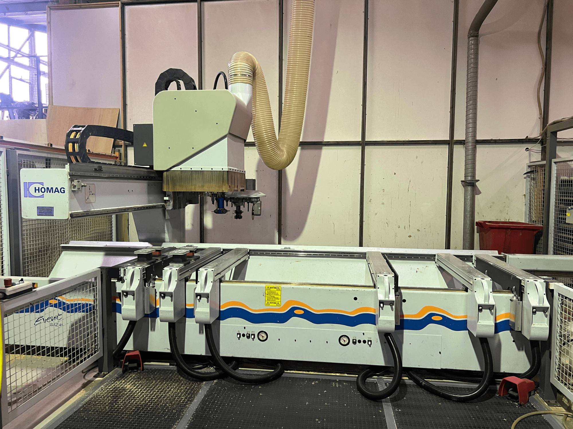 Macchina CNC HOMAG BIZ 4 in officina; vista frontale che mostra il sistema di aspirazione della polvere e il pannello di controllo con i cavi.