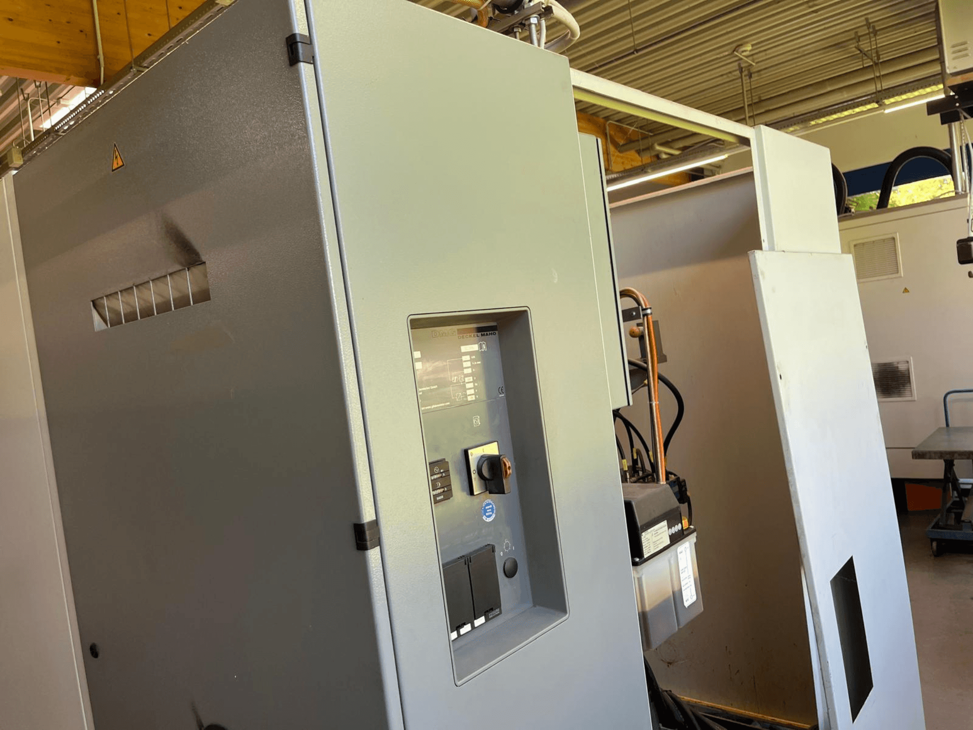 Centro di lavorazione verticale DMG DECKEL MAHO DMC 63 V, vista frontale che mostra il pannello di comando e lo sportello di accesso.