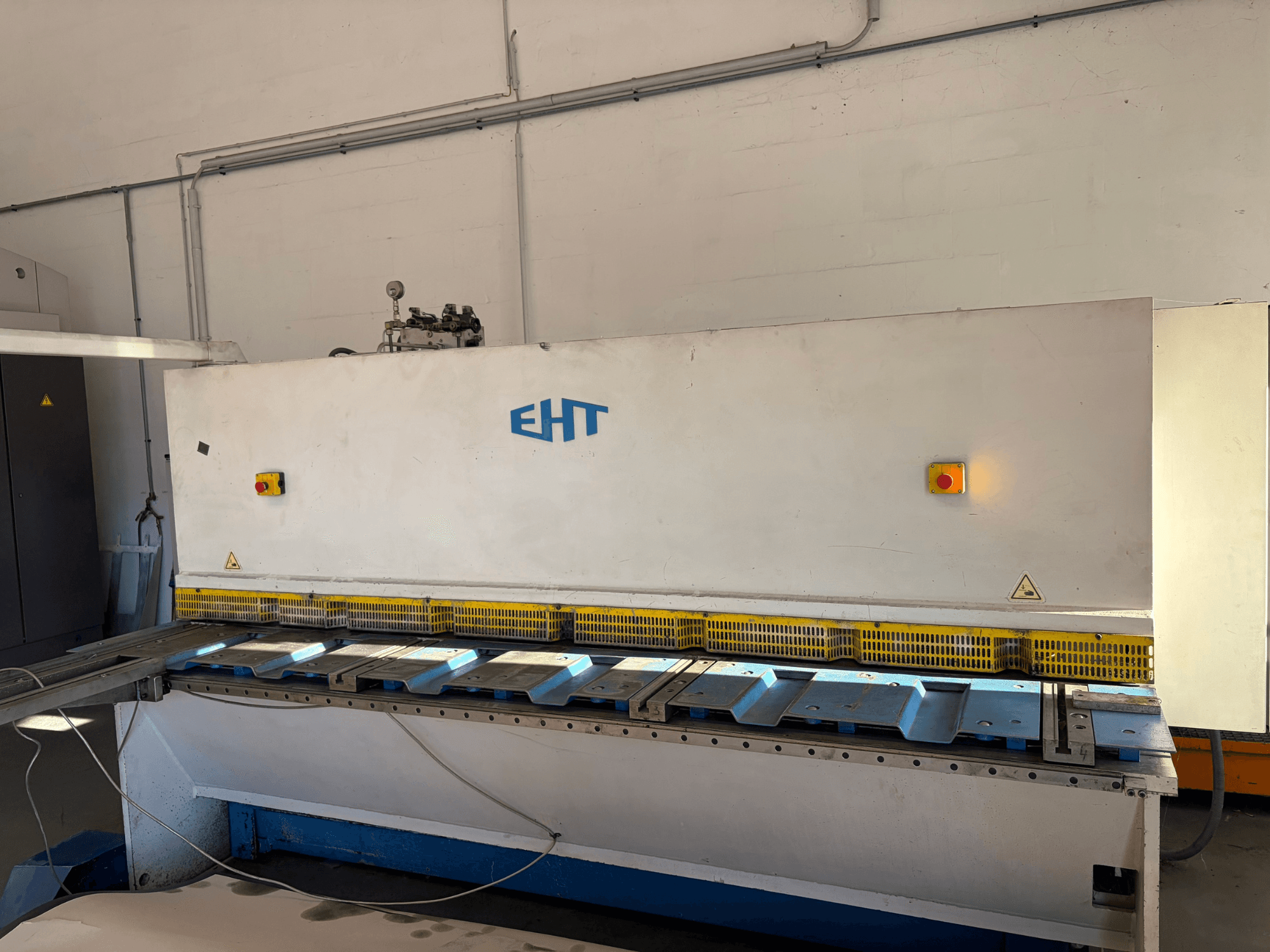 Cesoia idraulica EHT ISS 5-30 in un'officina, vista frontale che mostra il pannello di comando e la superficie di taglio.