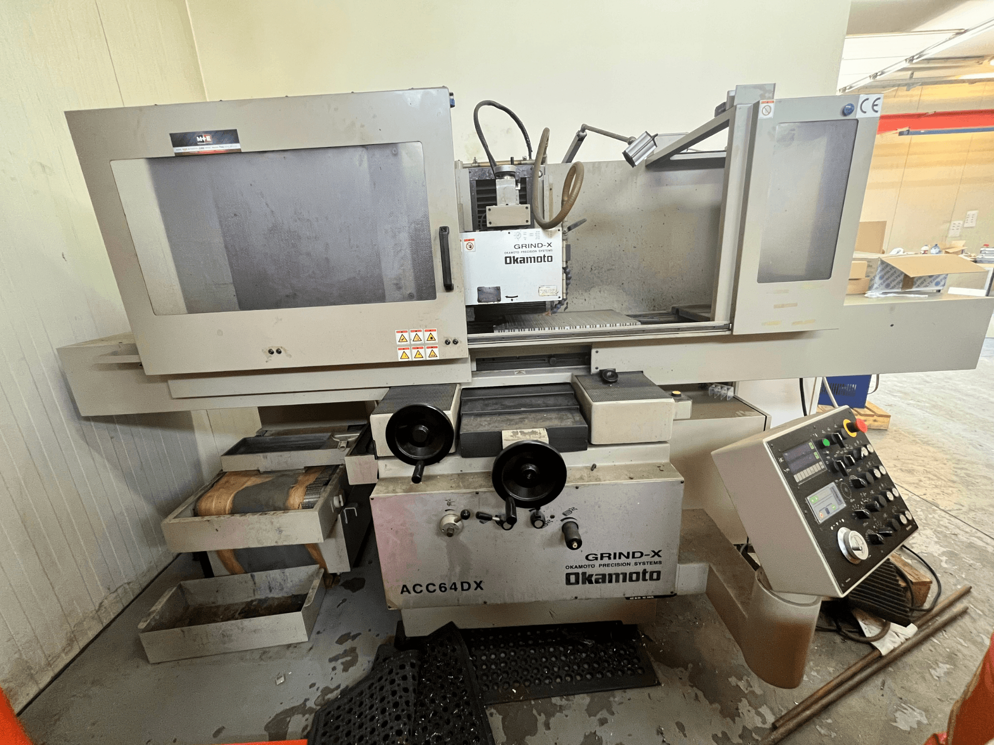 Rettificatrice piana Okamoto ACC64 DX vista frontale, con mola, pannello di controllo e cassetti portaoggetti.