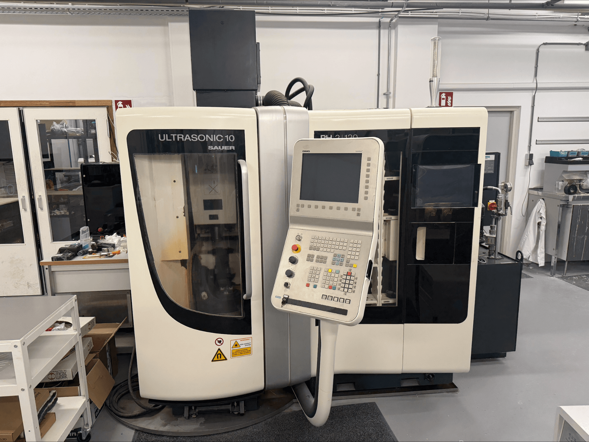 Centro di lavoro verticale DMG Sauer Ultrasonic 10 + PH 2 | 120, vista frontale, con pannello di controllo e ampia finestra di visualizzazione.