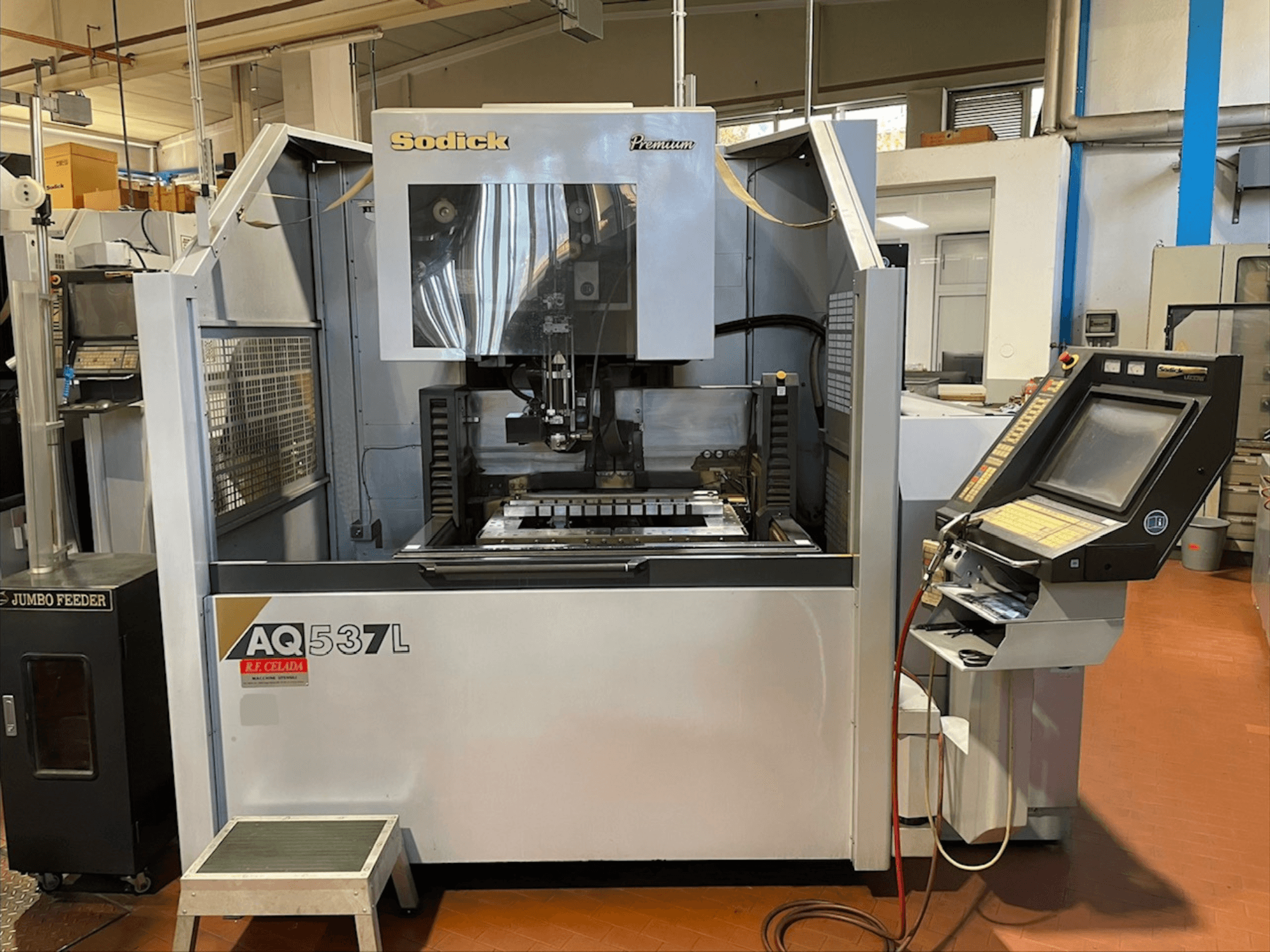 Macchina per elettroerosione a filo Sodick AQ537L in vista frontale, con pannello di controllo e area di lavorazione con componenti visibili.