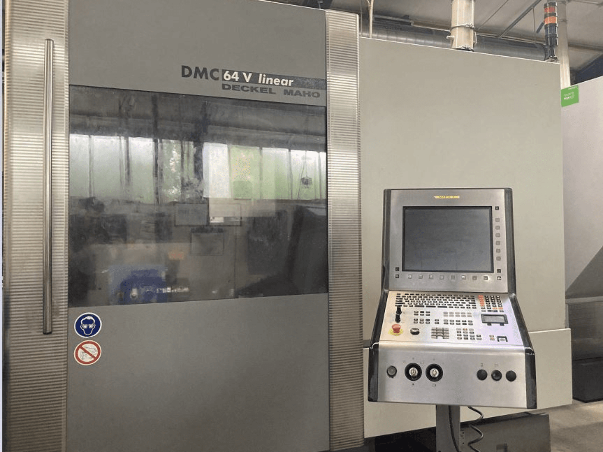 Centro di lavoro verticale lineare DMG DECKEL MAHO DMC 64V, vista frontale con pannello di controllo e display.