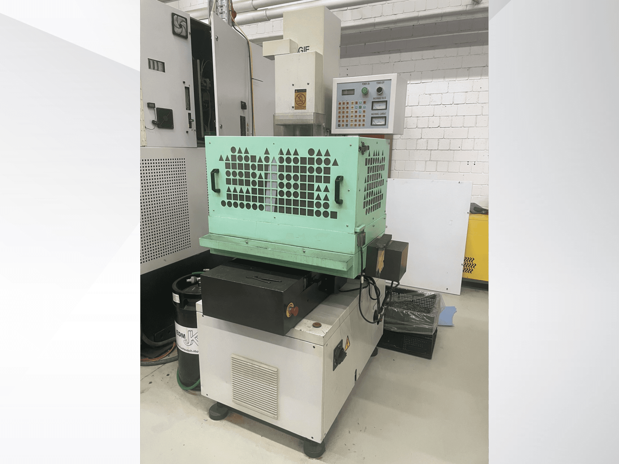 Trapano AGIE, macchina per la foratura dei metalli, vista frontale con comandi, involucro verde e design compatto. Ideale per lavori di precisione.