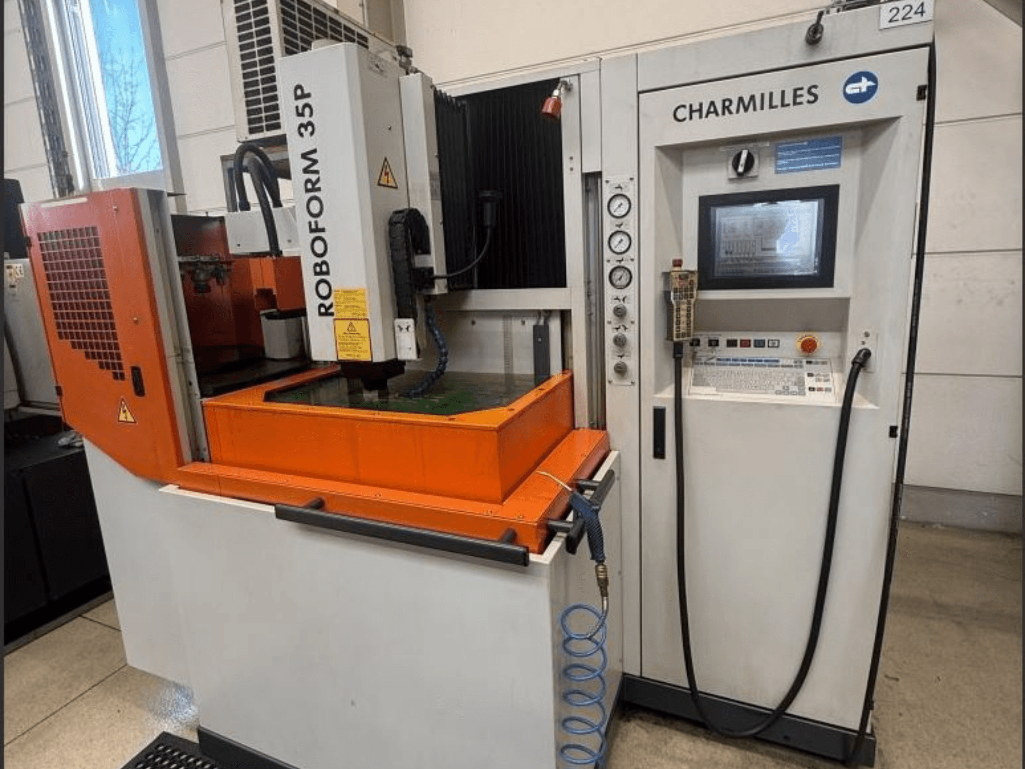 Macchina per elettroerosione a tuffo ROBOFORM 35P di Charmilles, vista frontale, con pannello di controllo, portale e serbatoio del fluido in funzione.