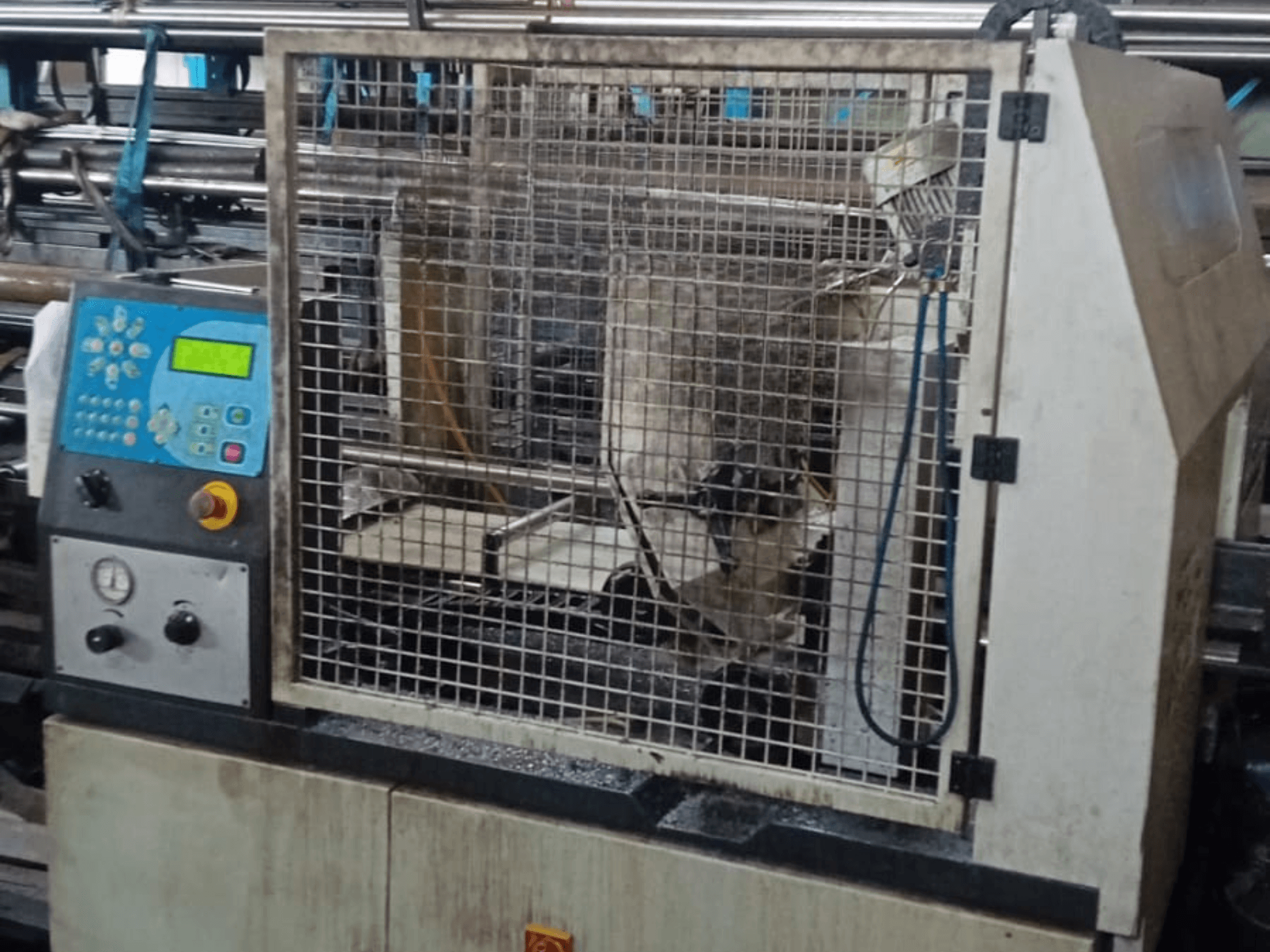 Sega a nastro per metalli Macc 381 AV, vista frontale, che mostra il pannello di controllo, la gabbia di sicurezza e i detriti di metallo sulla base.