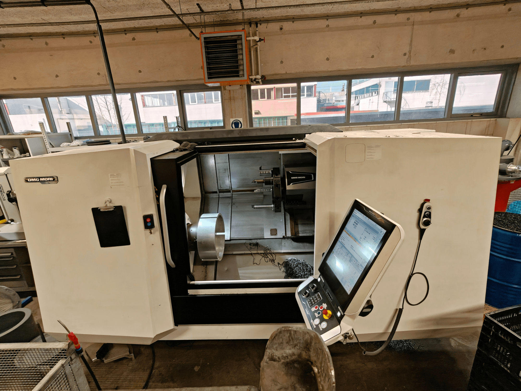 Vista frontale di un tornio orizzontale DMG MORI CLX 550, che mostra il pannello di controllo e l'area di lavoro aperta.