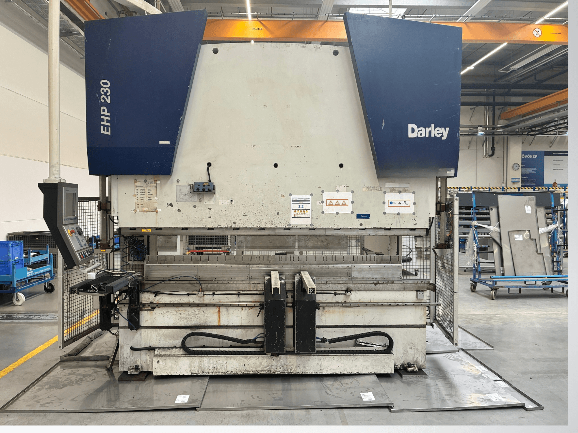 Pressa idraulica Darley EHP-LS 230.31/25, vista frontale, con pannello di controllo e lamiere vicine. Ideale per applicazioni industriali.
