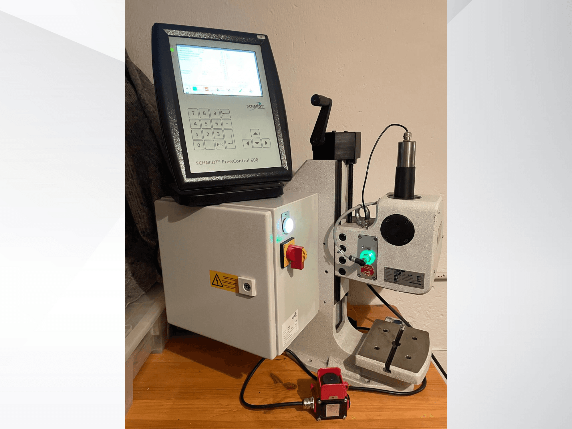 SCHMIDT® PressControl 600, vista frontale, con pannello di controllo, pulsante di accensione e pressa idraulica con funzioni di sicurezza.