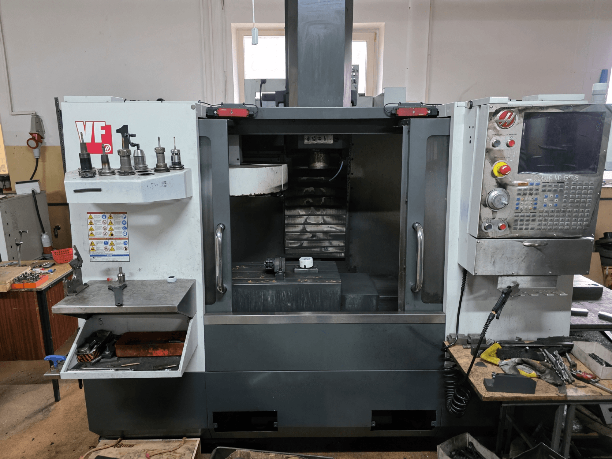 Fresatrice CNC Haas serie VF, vista frontale; dispone di più portautensili, pannello di controllo e area di lavoro visibile.