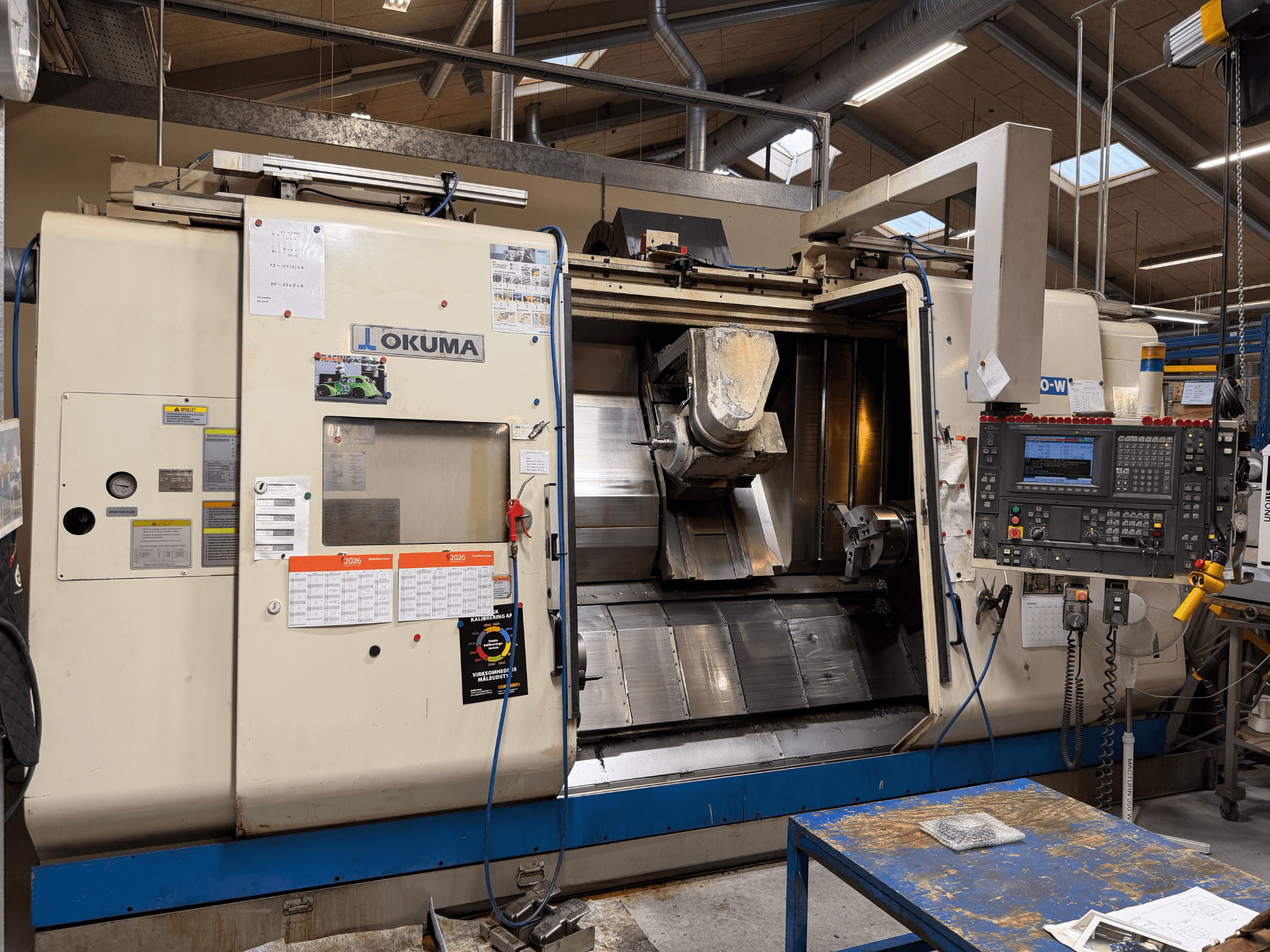Centro di tornitura-fresatura Okuma MacTurn350-W, vista frontale che mostra il pannello di controllo e l'accesso libero all'area di lavorazione.