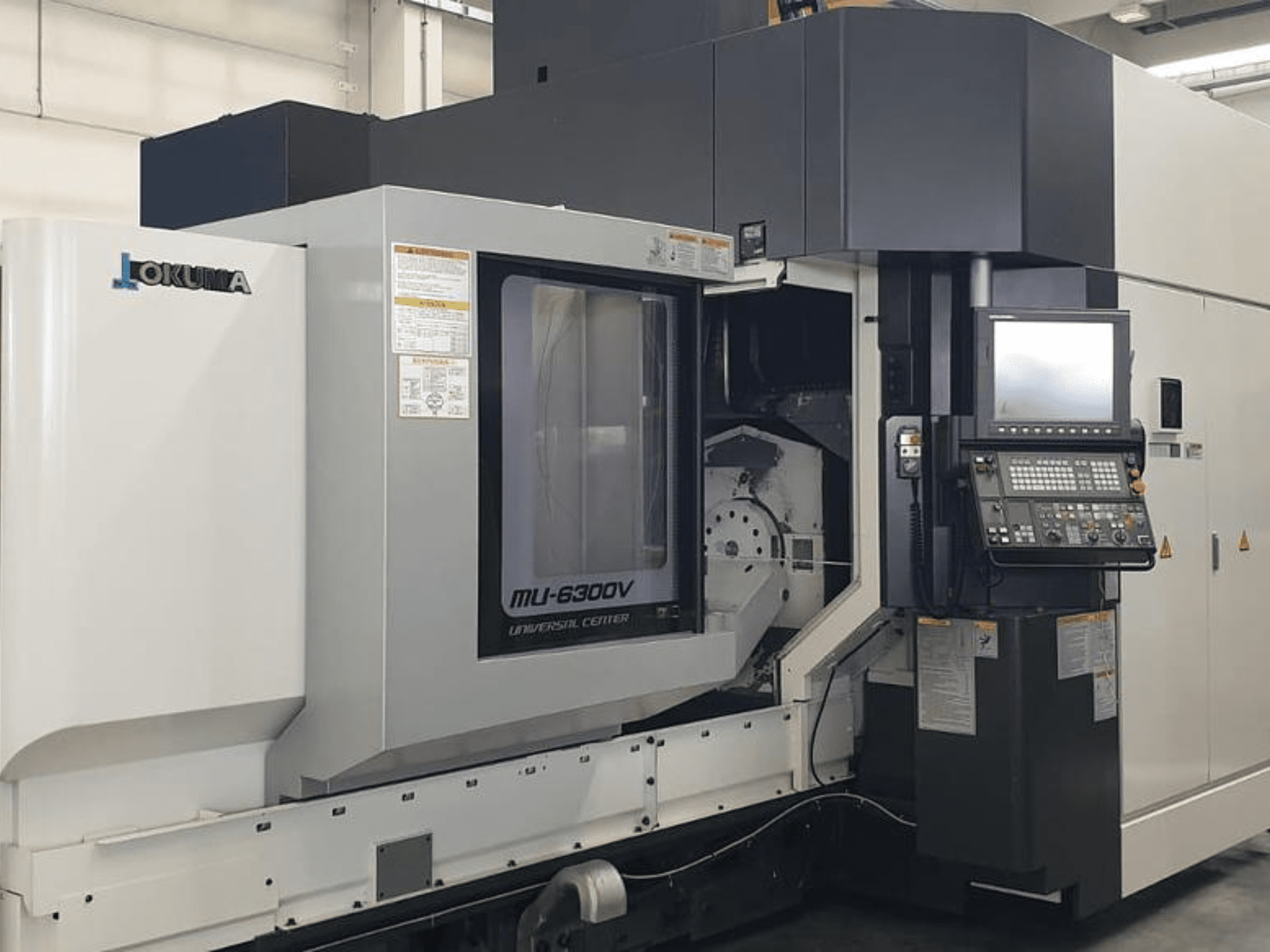 Centro di lavoro verticale Okuma MU 6300 V, vista frontale che mostra il pannello di controllo e i dettagli dell'area di lavorazione.