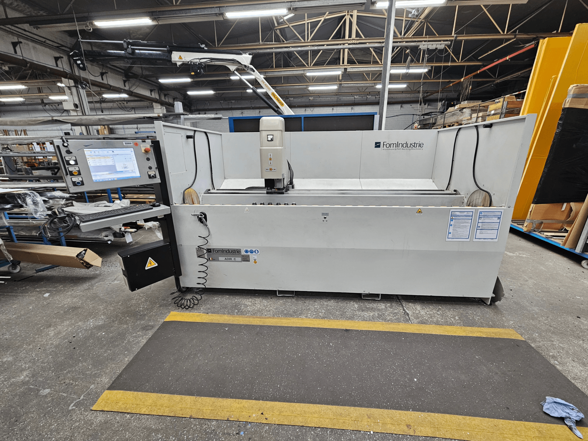 Centro di lavoro verticale FomIndustrie ADIR C in officina, vista frontale con pannello di controllo e dettagli della macchina.