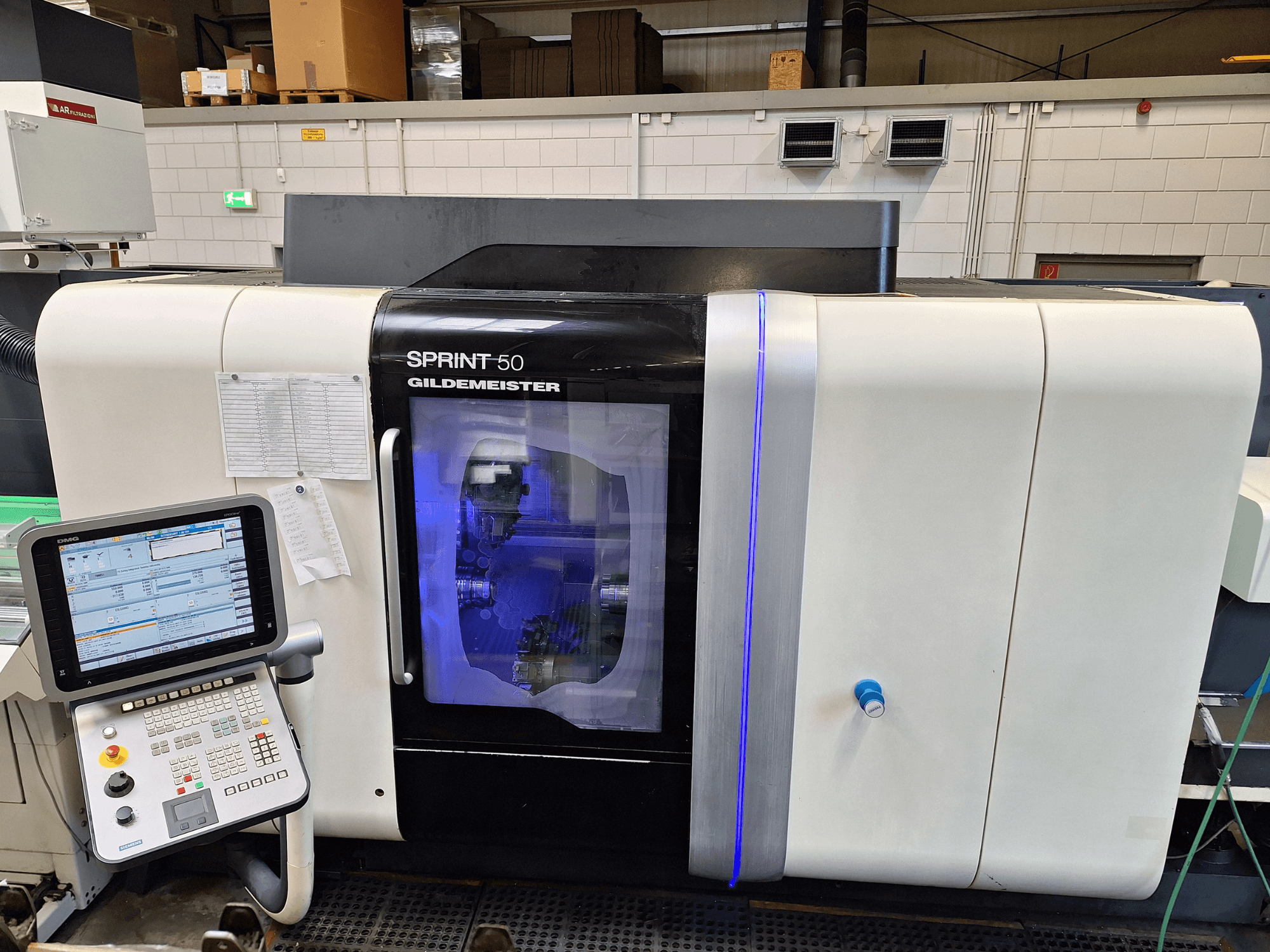 Tornio orizzontale DMG Sprint 50 2T, vista frontale, con pannello di controllo e carter trasparente che mostra i macchinari all'interno.