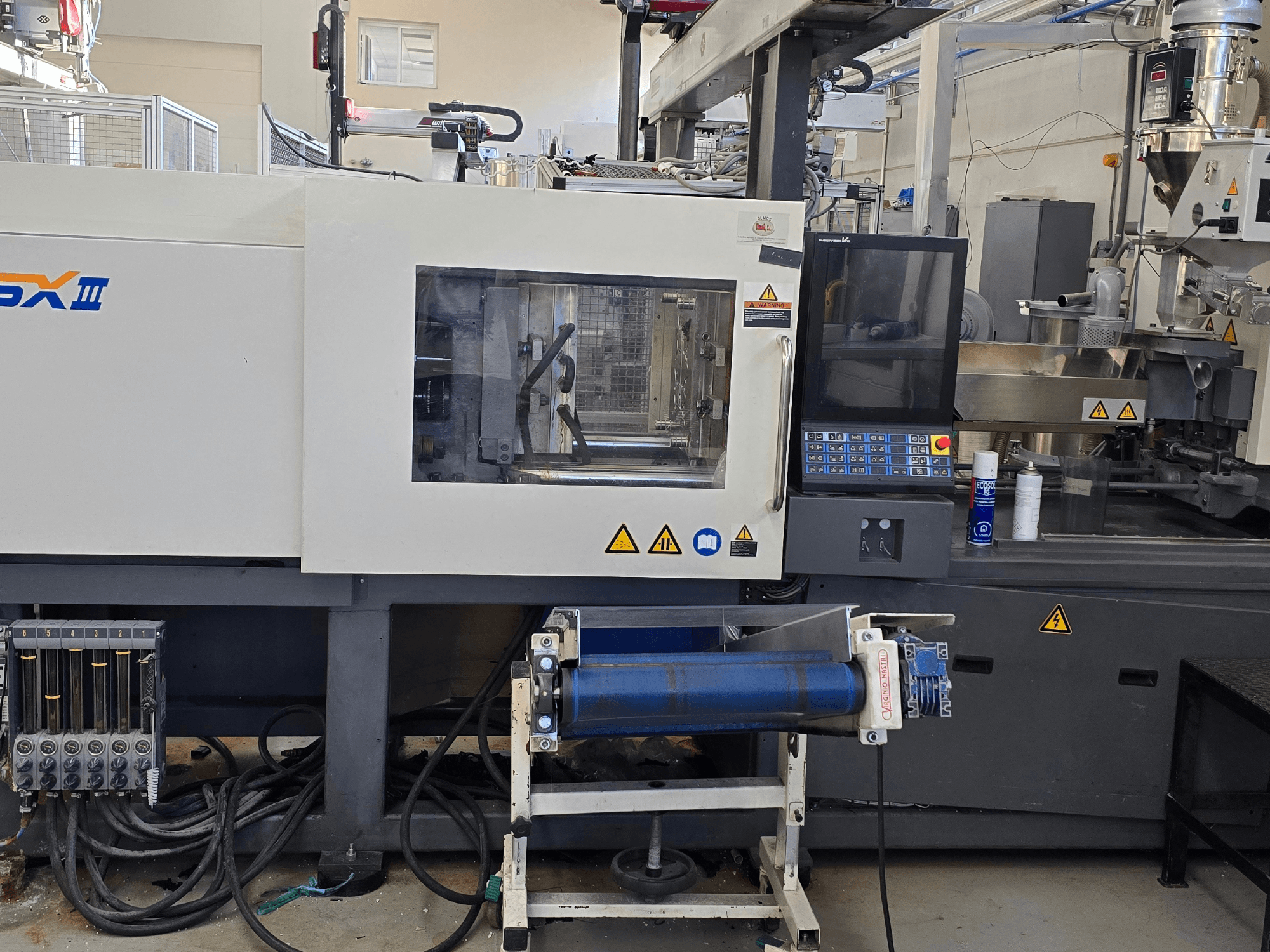 Macchina ad iniezione elettrica SHIBAURA EC130SXIII-4A, vista frontale, con pannello di controllo e componenti idraulici.