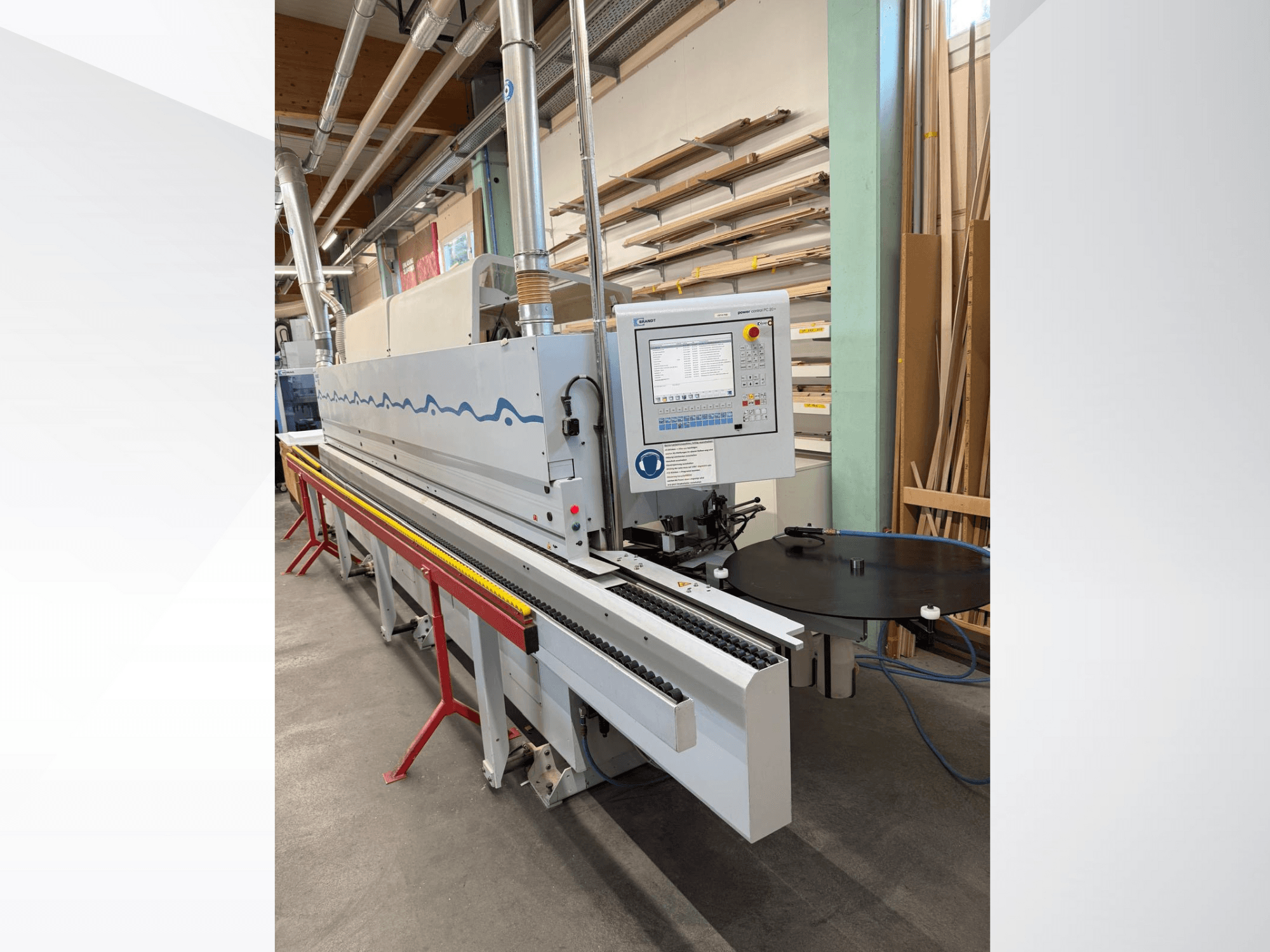 Vista frontale di una bordatrice automatica HolzHer con pannello di controllo, sistema di trasporto e tavolo di supporto rotondo.