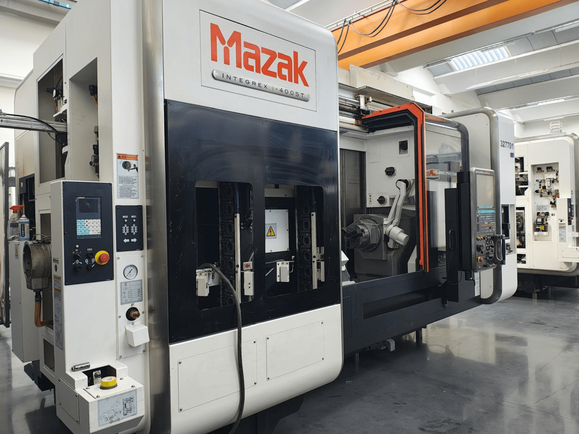 Mazak Integrex 400ST, vista frontale; macchina CNC con pannello di controllo, mandrini e braccio robotico visibili in un'officina.
