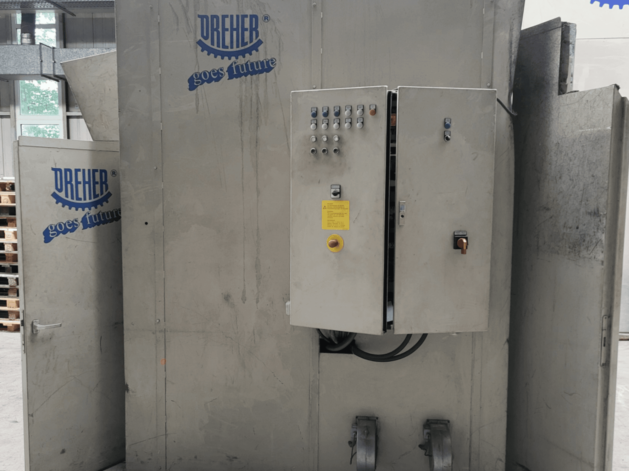 Macchina per la lavorazione della plastica DREHER S 42/65 GFS-15 GR, vista frontale che mostra il pannello di controllo e il marchio, ambiente industriale.