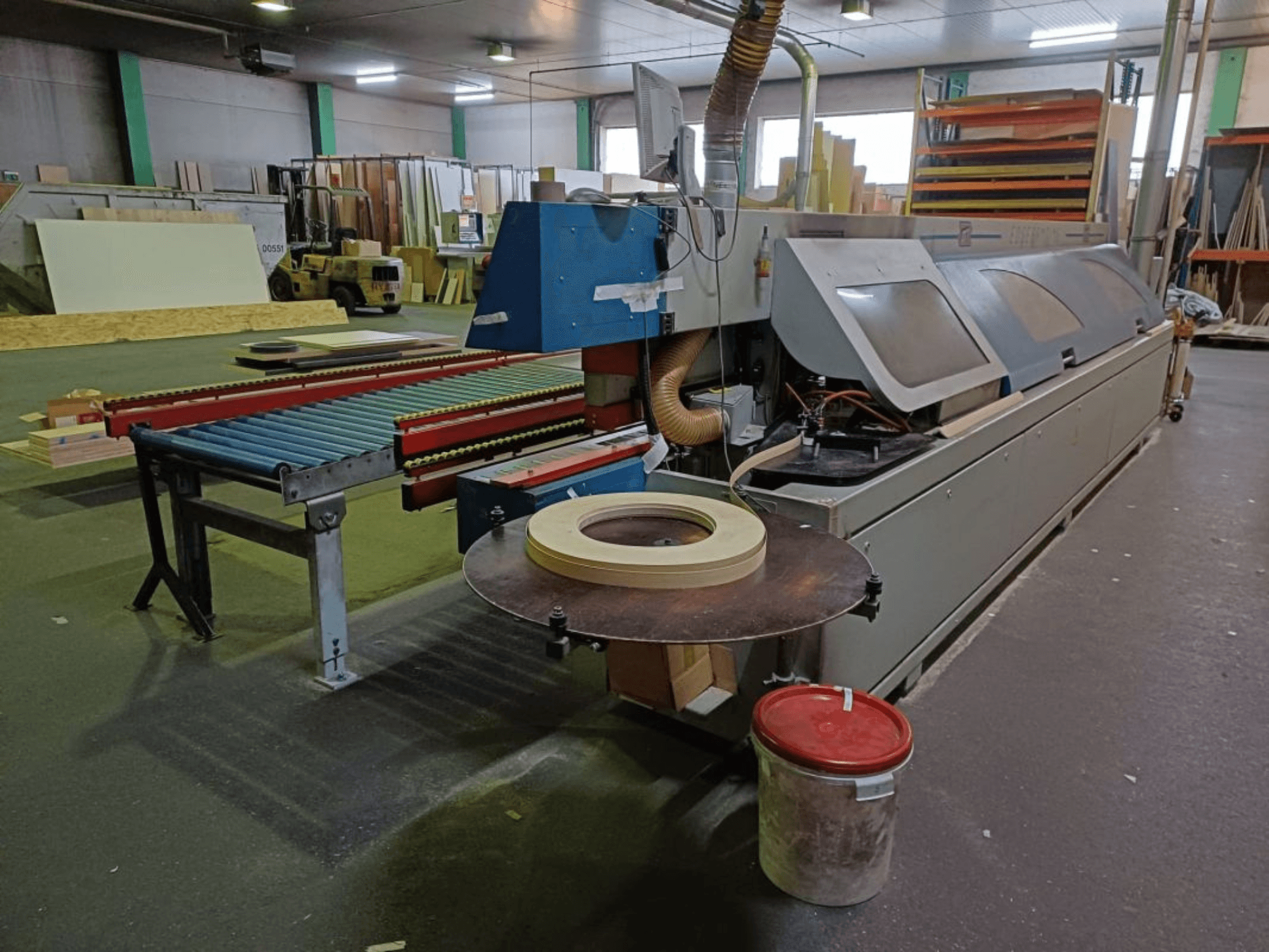 Bordatrice OTT TWISTER in un'officina, con trasportatore a rulli e sega circolare, vista di lato.