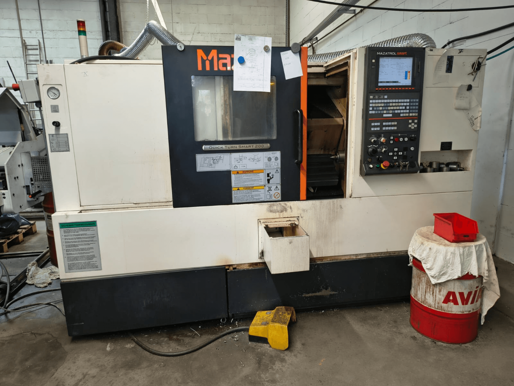 Mazak Quick Turn Smart 200, tornio orizzontale, vista frontale con pannello di controllo, serbatoio del liquido di raffreddamento e marcature visibili.