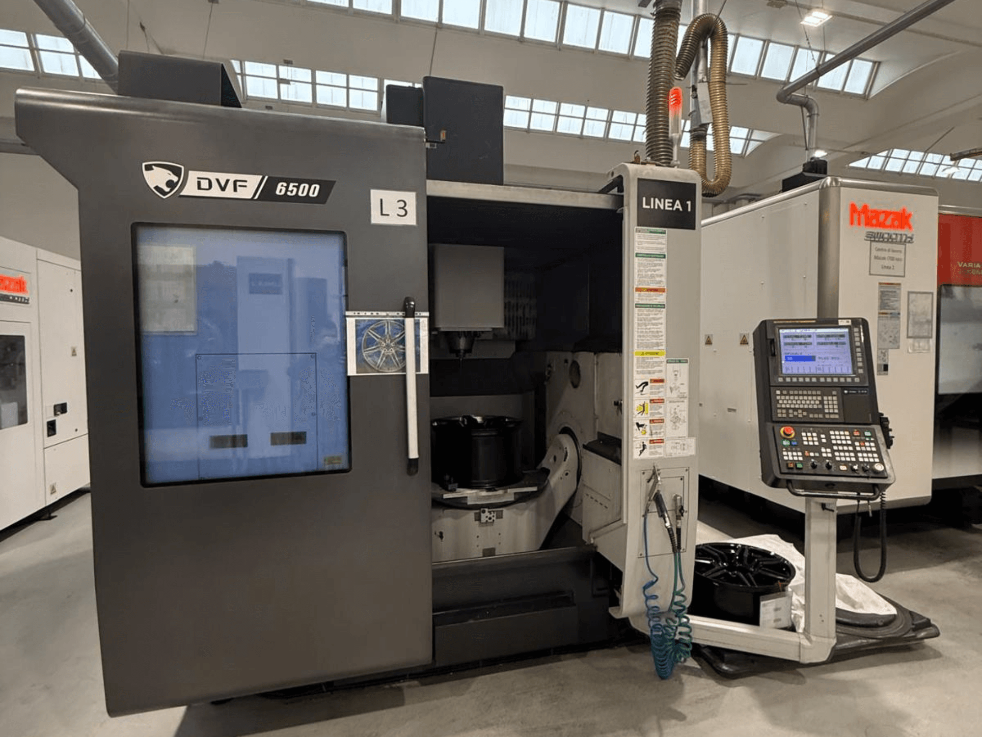 Macchina CNC DVF 6500, vista frontale, con pannello di controllo e spazio interno con attrezzatura per pezzi.