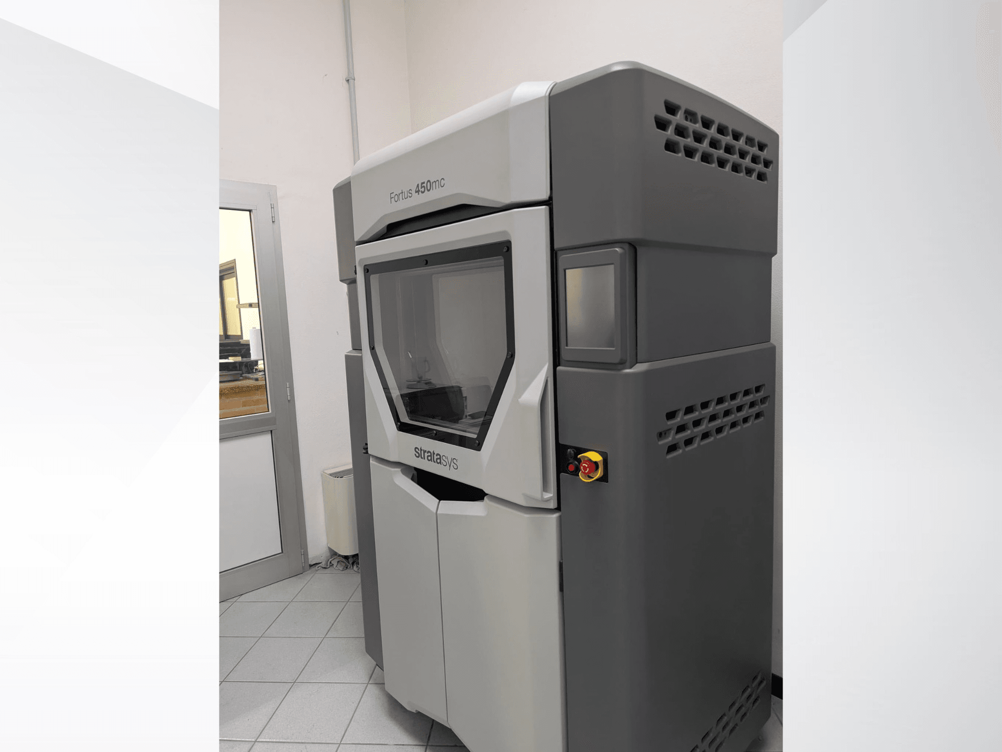 La stampante 3D in plastica Stratasys FORTUS 450mc in una vista laterale, che mostra un design elegante e un pannello di controllo.