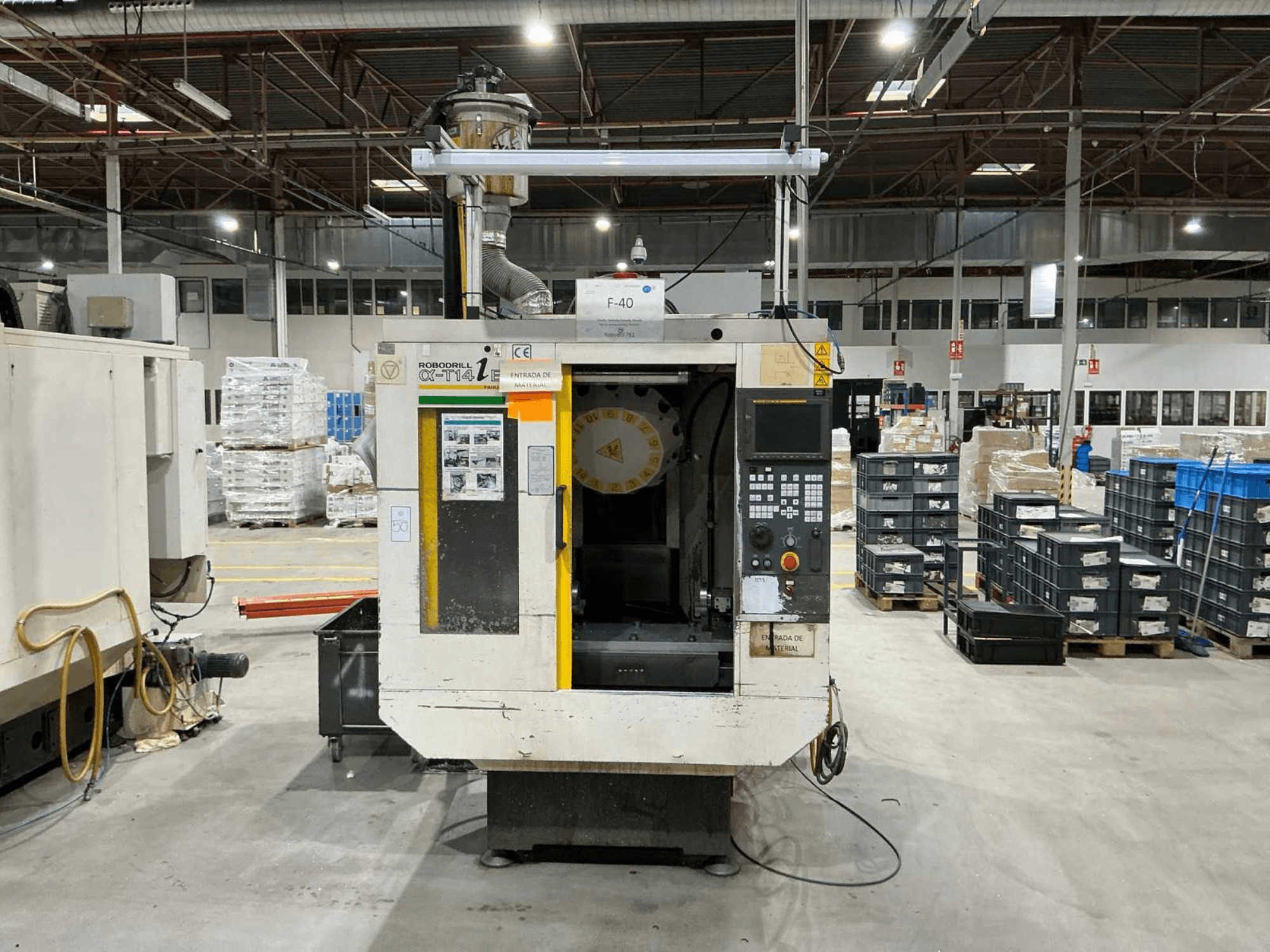 Centro di lavoro verticale FANUC ROBODRILL α-T14iB in uno stabilimento, vista frontale con pannello di controllo e portautensili.