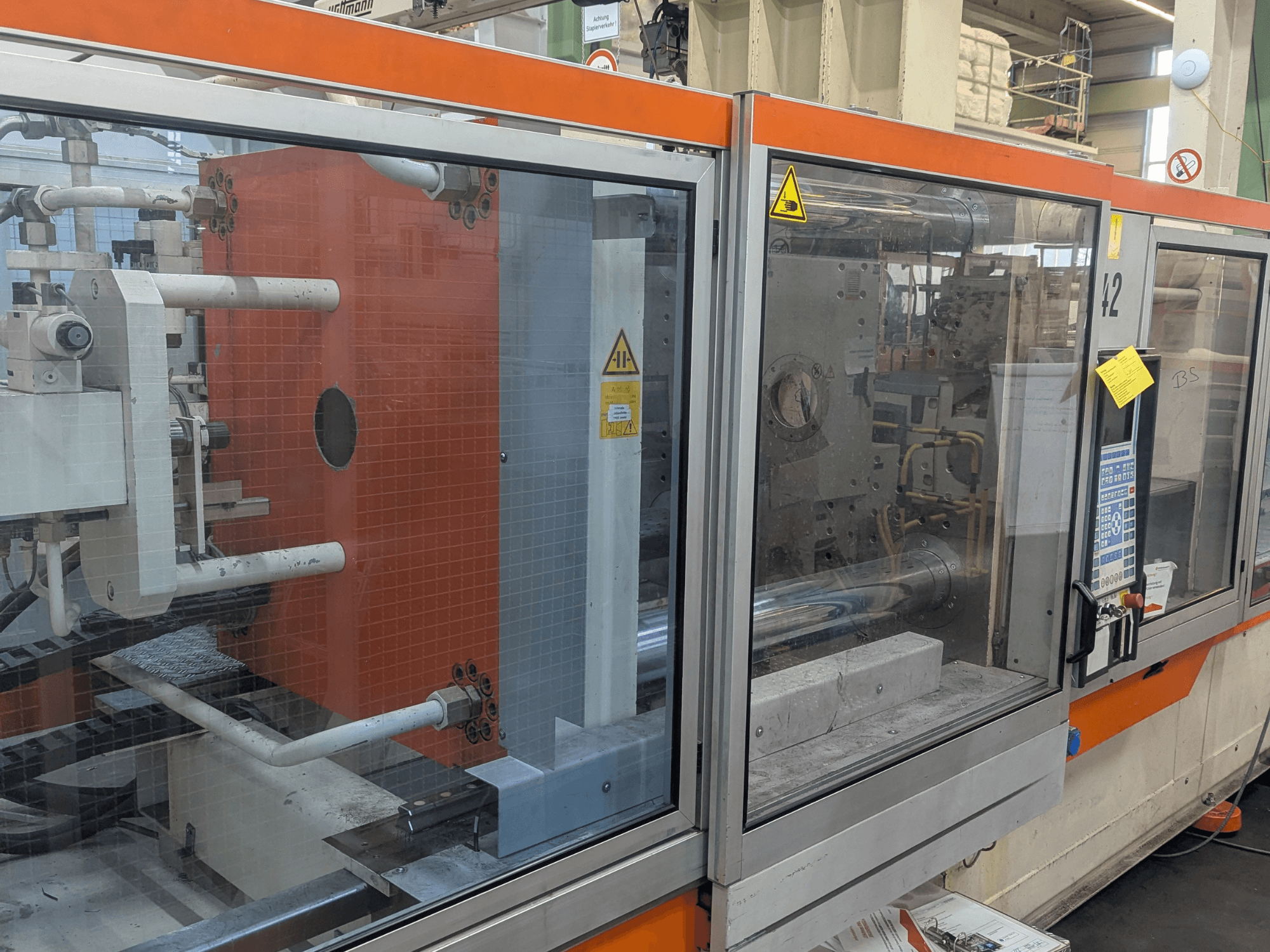 Vista frontale di una pressa a iniezione idraulica DEMAG SYSTEC 80/420-310 con pannello di controllo e componenti della macchina visibili.