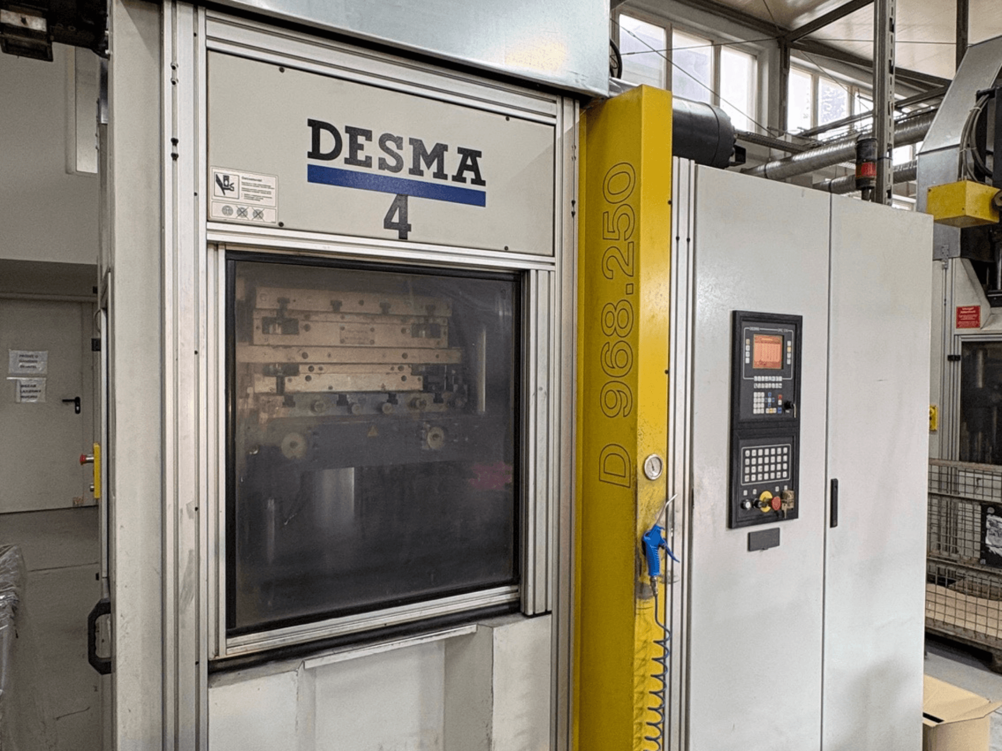 Pressa a iniezione verticale Kloeckner Desma 968.250, vista frontale con pannello di controllo e dettagli della macchina.