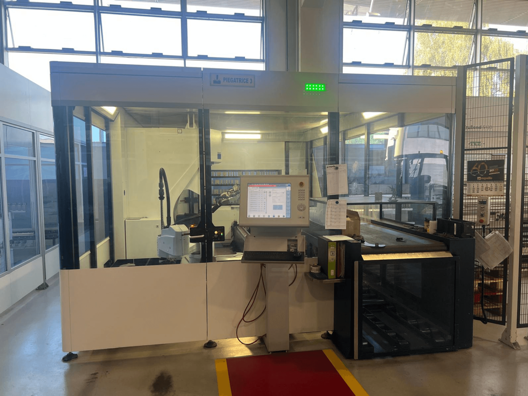 Piegatrice industriale, modello Piegatrice 3, vista frontale con pannello di controllo e braccio robotico, in un'officina ben illuminata.