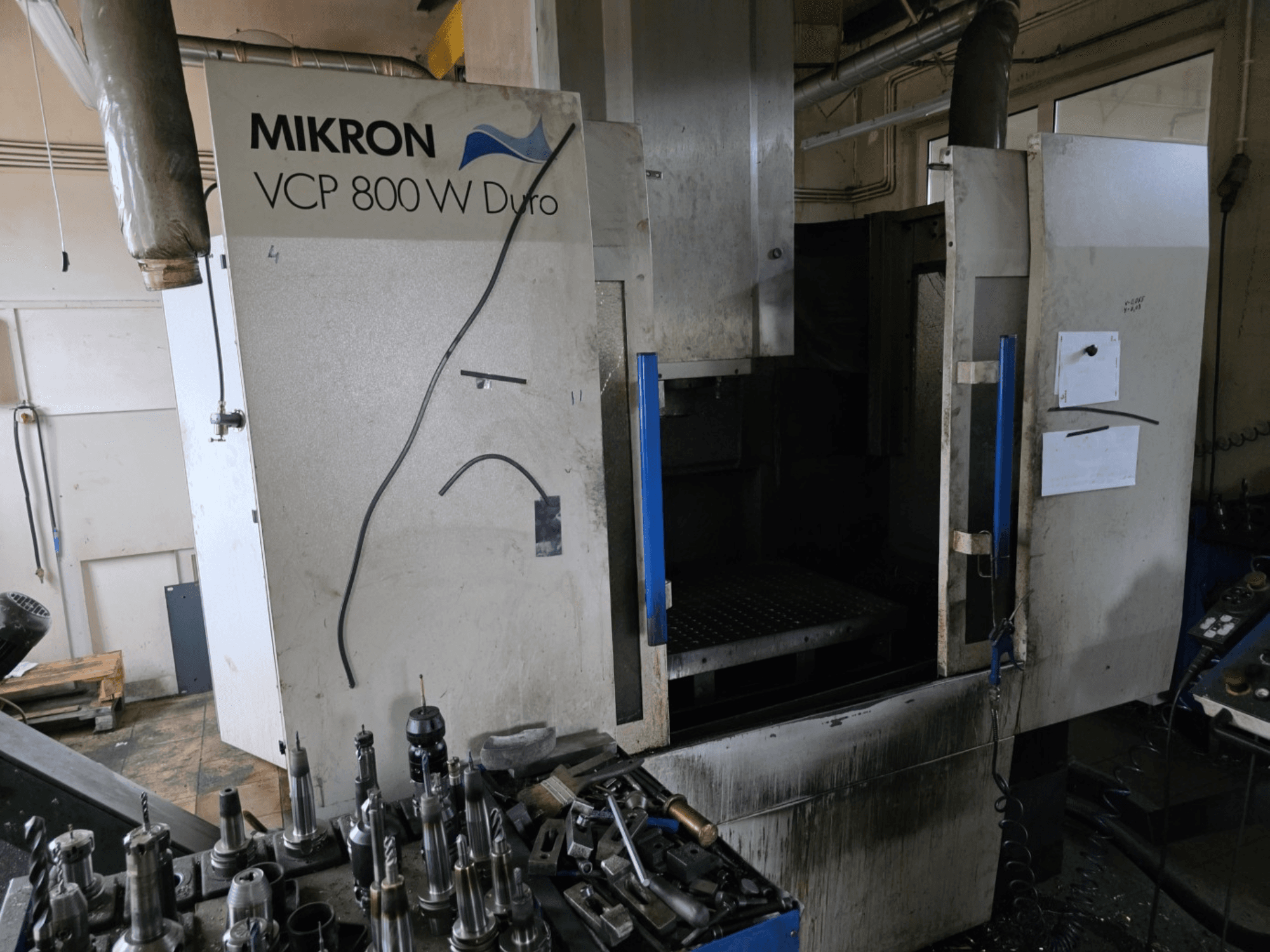 Fresatrice Mikron VCP 800 W Duro vista di lato, con utensili e comandi visibili in primo piano.