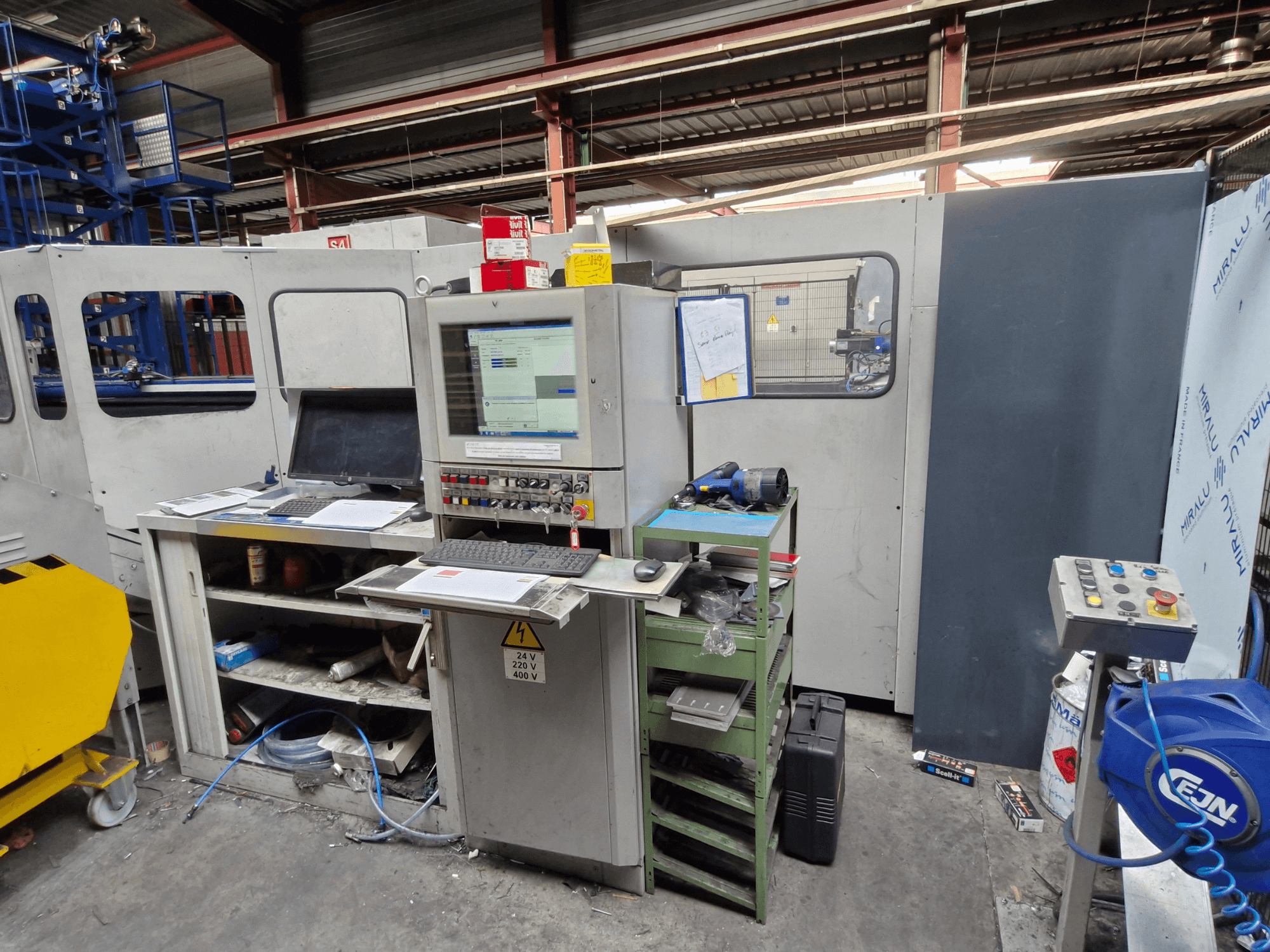 Punzonatrice CNC Salvagnini S4-40 in un'officina, con pannello di controllo con monitor e utensili, vista frontale.