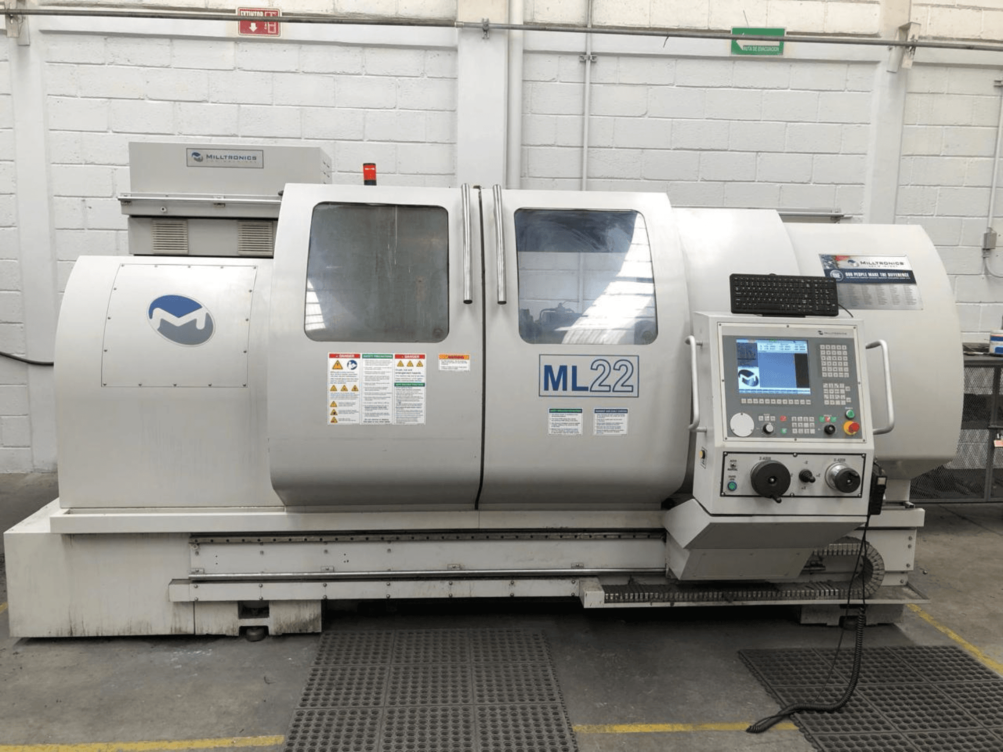 Centro di lavoro verticale MILLTRONICS RH 20, vista frontale che mostra il pannello di controllo, il logo del marchio e le etichette di sicurezza sulla macchina.