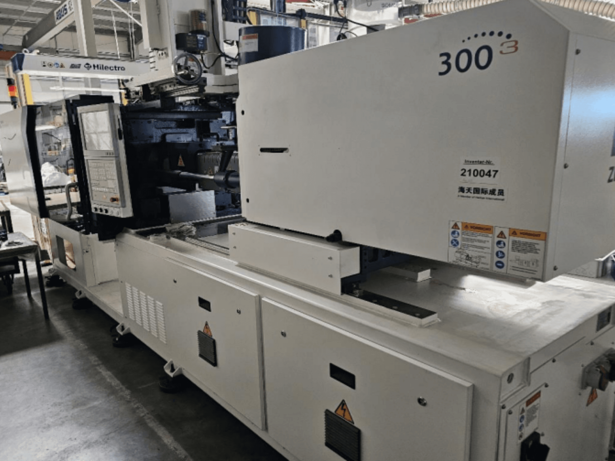 Pressa a iniezione, marca Zhenjing, modello 300, vista frontale con pannello di controllo ed etichette di sicurezza visibili.