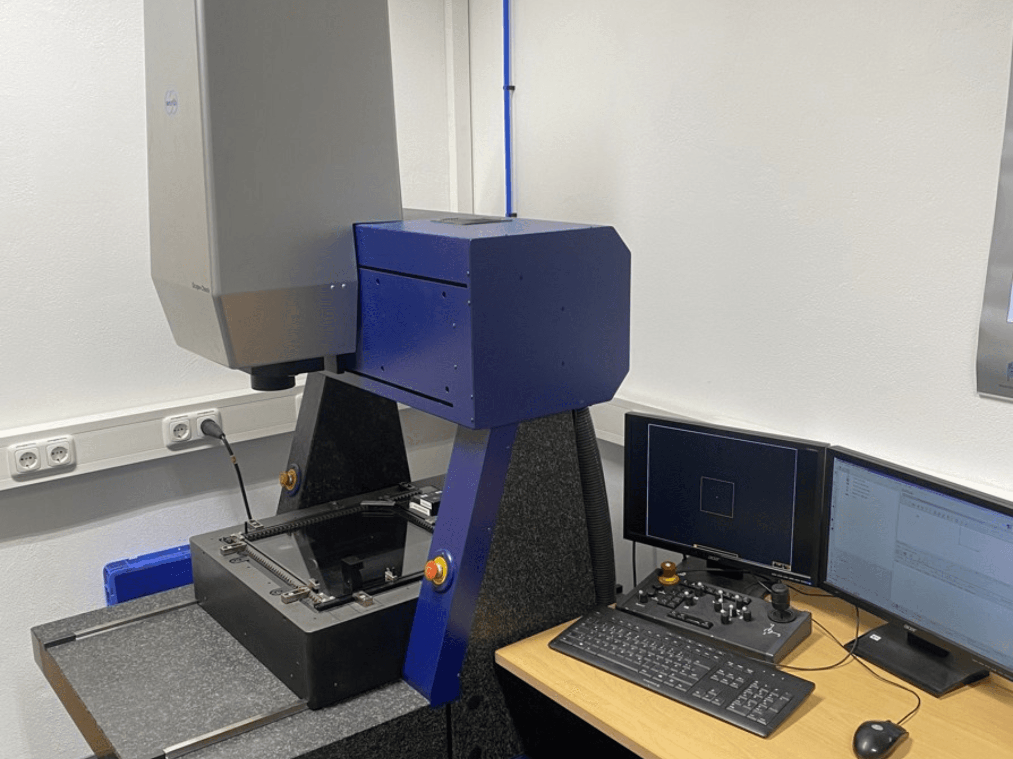 La CMM Werth Scope-Check 400 in laboratorio, con la testa di misura e il pannello di controllo con schermi e tastiera.