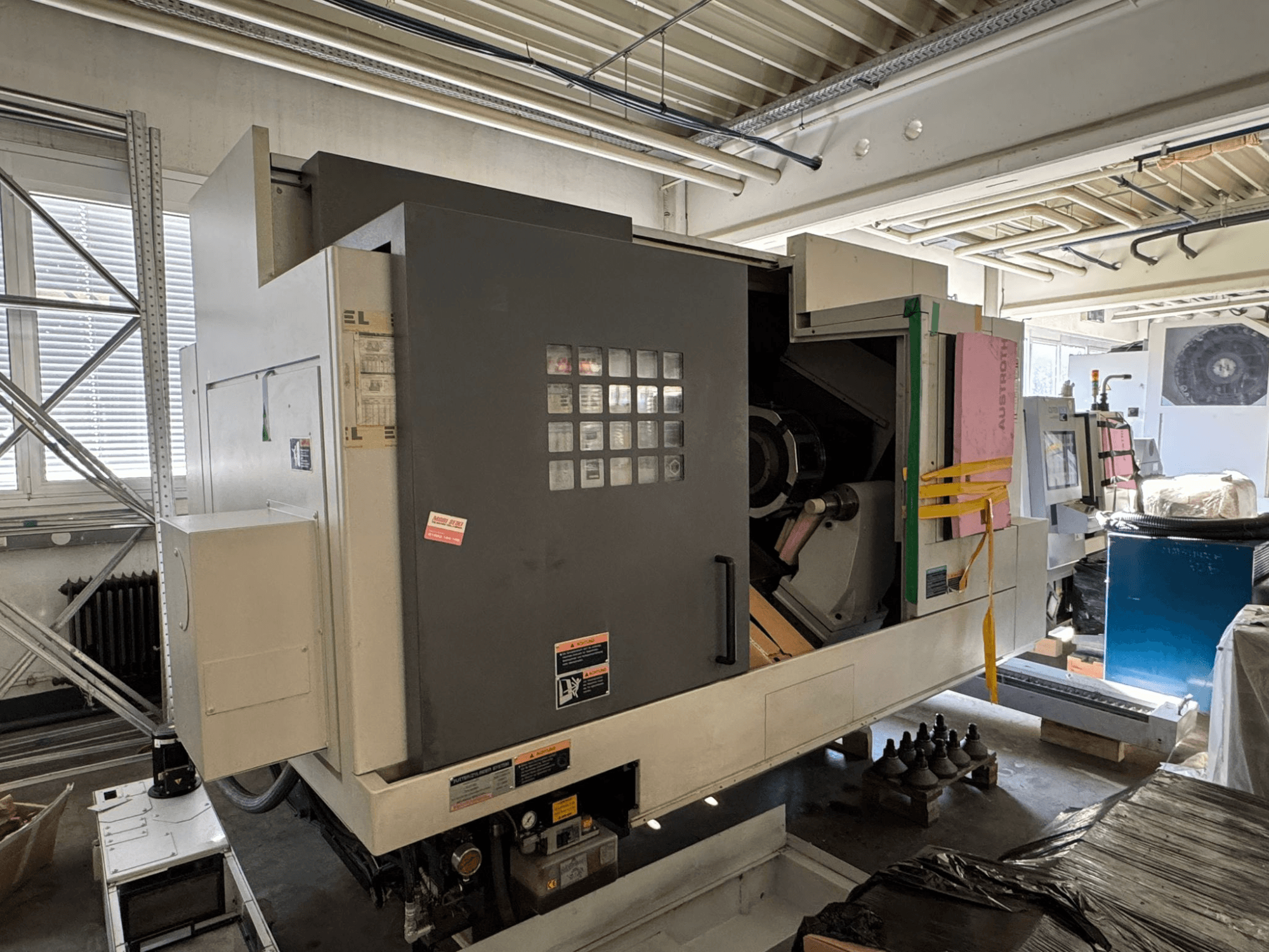 Tornio orizzontale MORI SEIKI NL 3000 MC/700, vista frontale con pannello di controllo, area di stoccaggio e copertura protettiva.