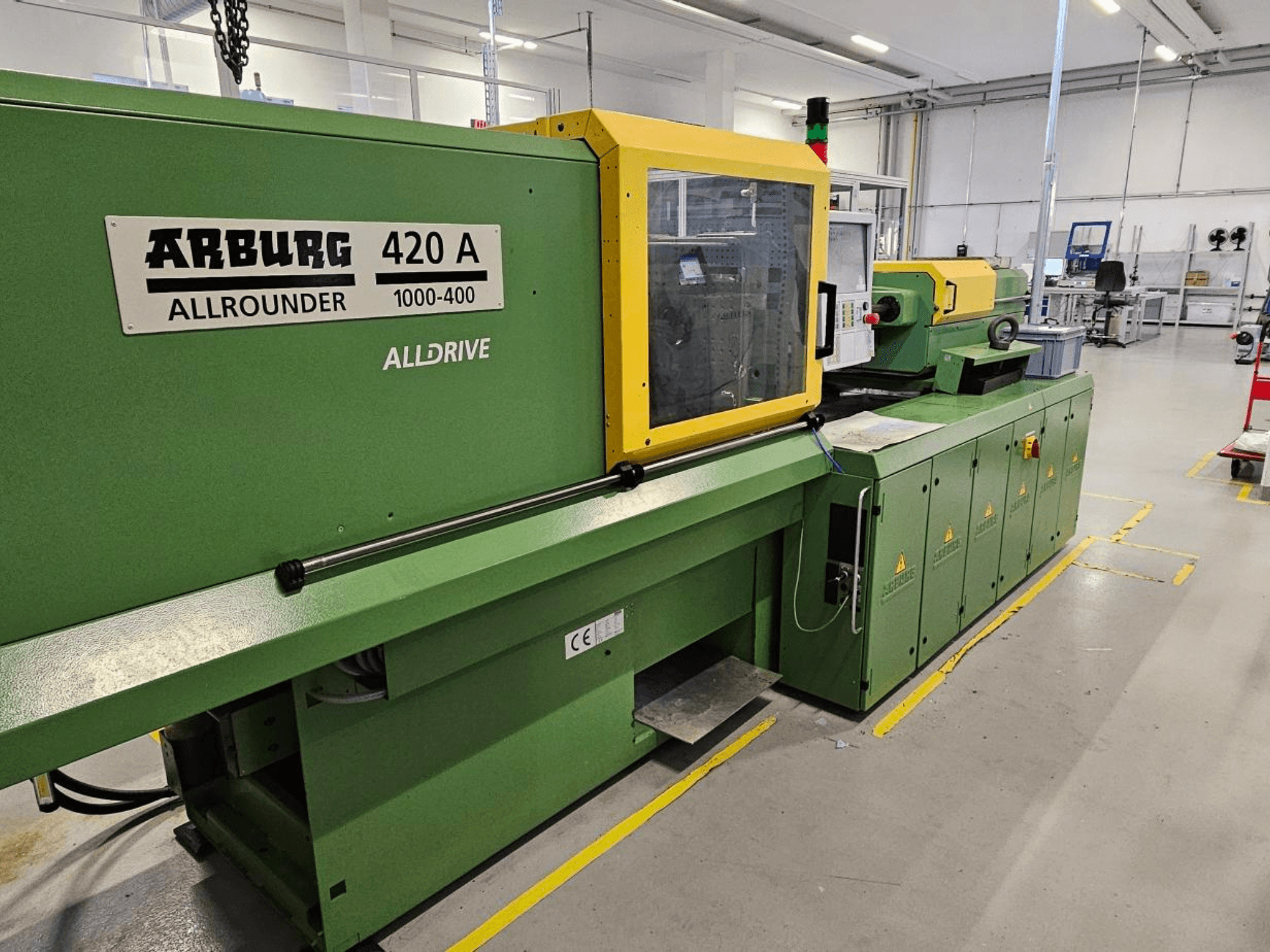 ARBURG 420 A Allrounder 1000-400, vista frontale; macchina verde con pannello giallo, touchscreen e funzioni di sicurezza.
