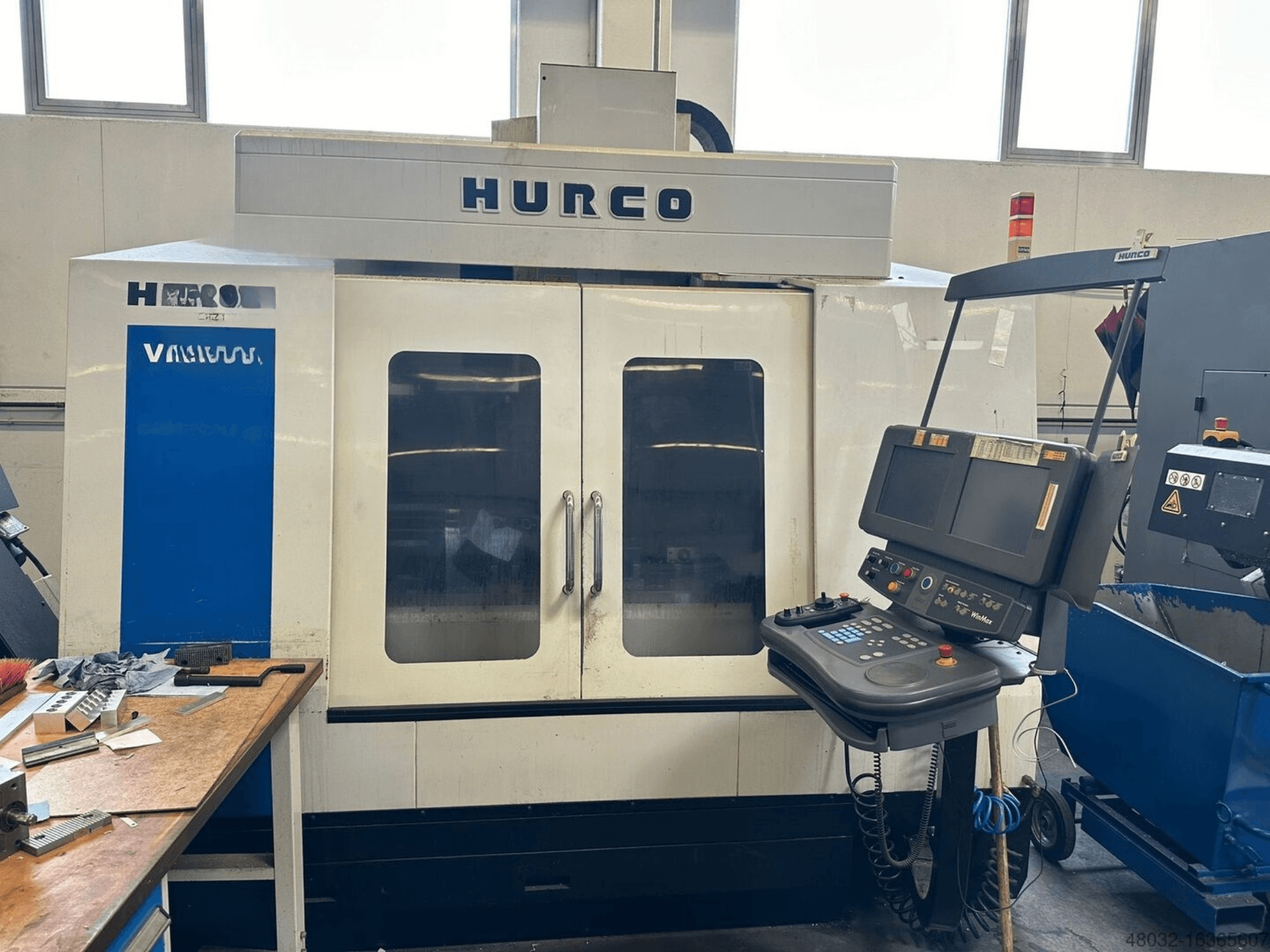 Centro di lavorazione verticale Hurco VMX42t dotato di pannello di controllo e ampie finestre di visualizzazione, raffigurato in un'officina.