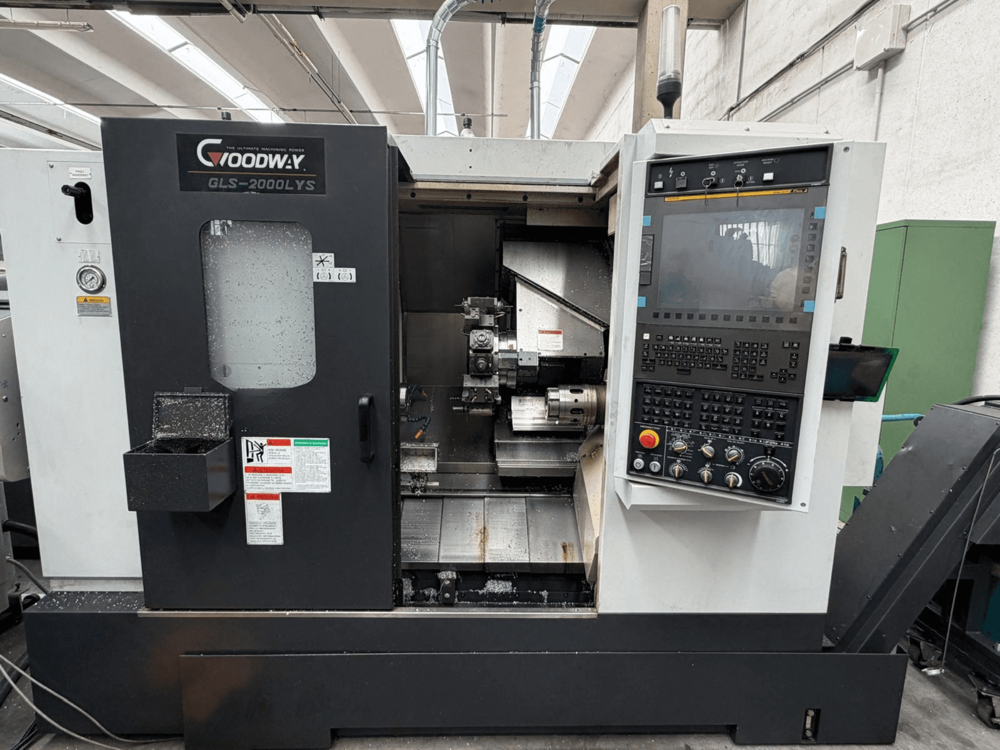 Tornio orizzontale Goodway GLS-2000LYS visto frontalmente, con pannello di controllo e trucioli metallici visibili.