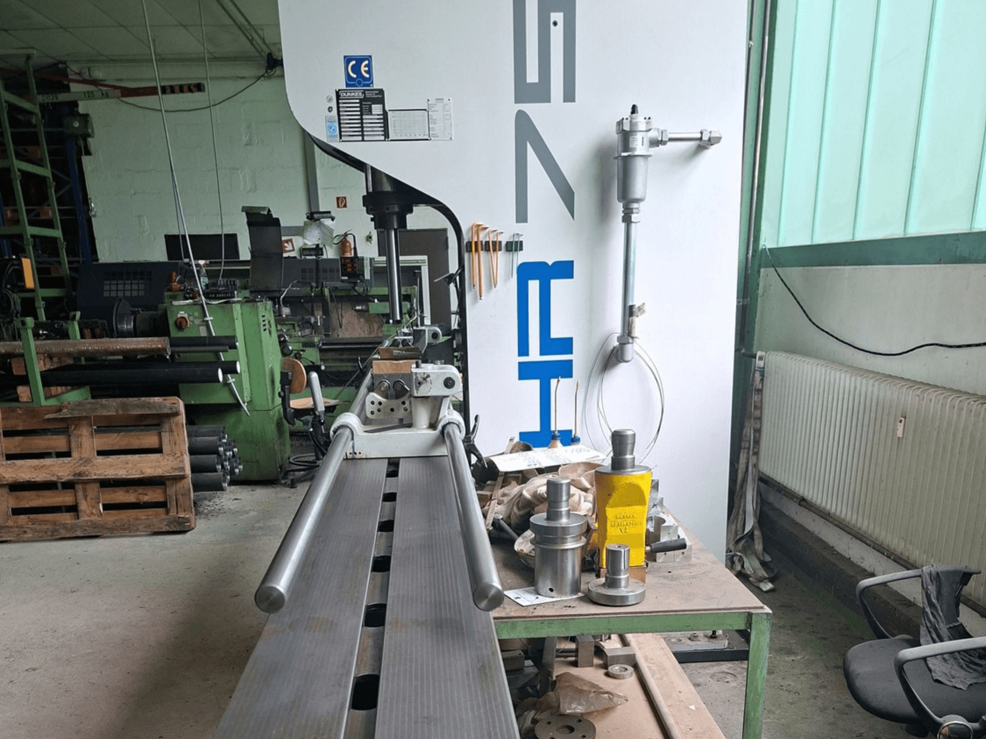 Pressa per metalli Dunkes HR75 in officina, vista laterale che mostra il profilo e gli utensili circostanti sul tavolo.